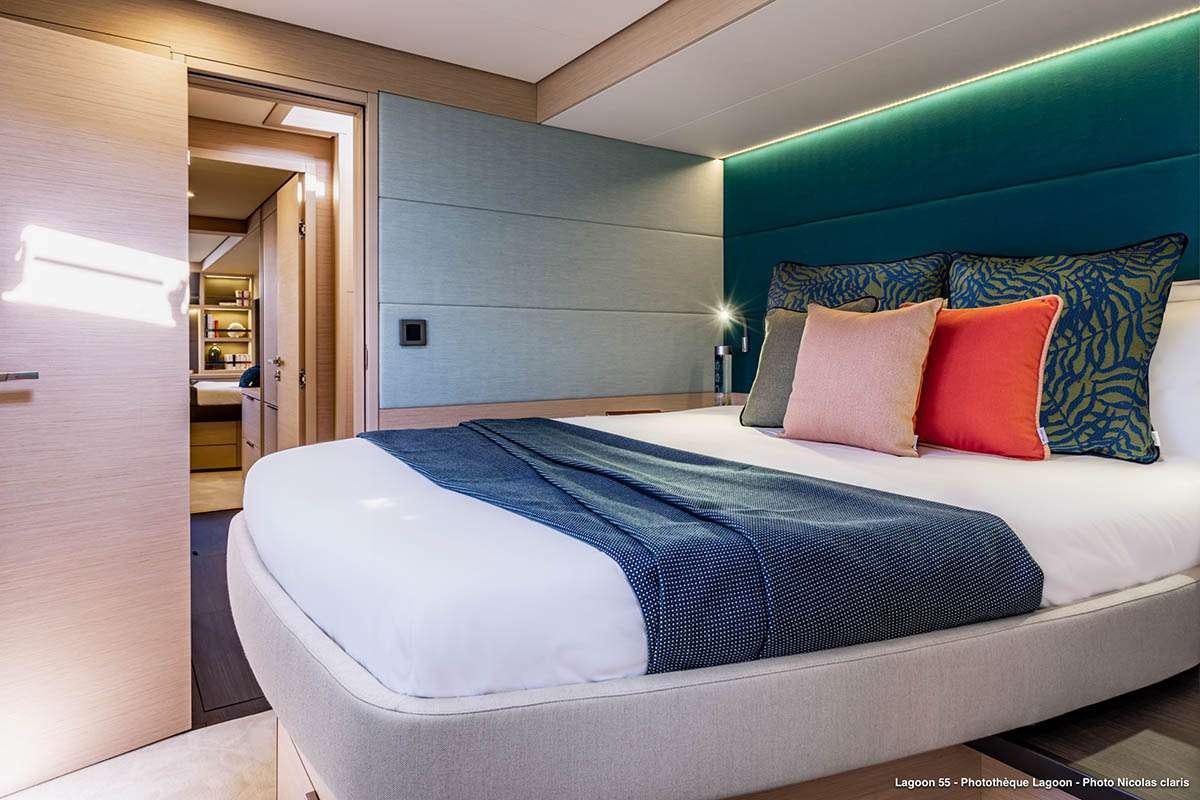a bed with blue sheets aboard VALINOR Yacht for Charter