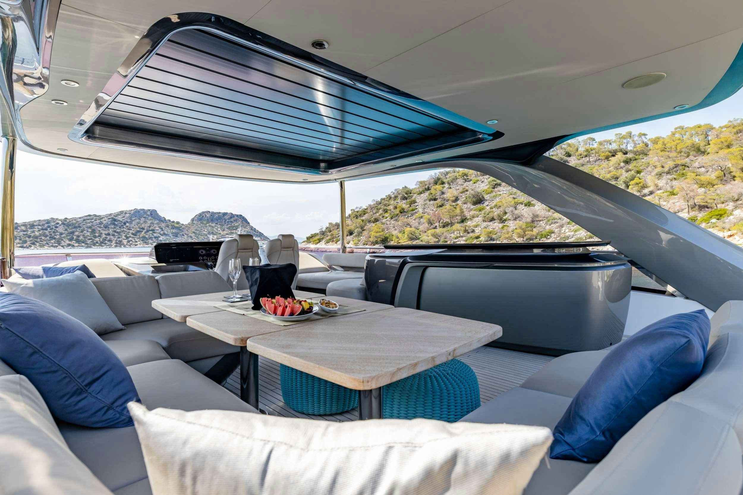 a large lounge area with a large lounge chair and a large blue and white tent with a view aboard VISTA Yacht for Charter