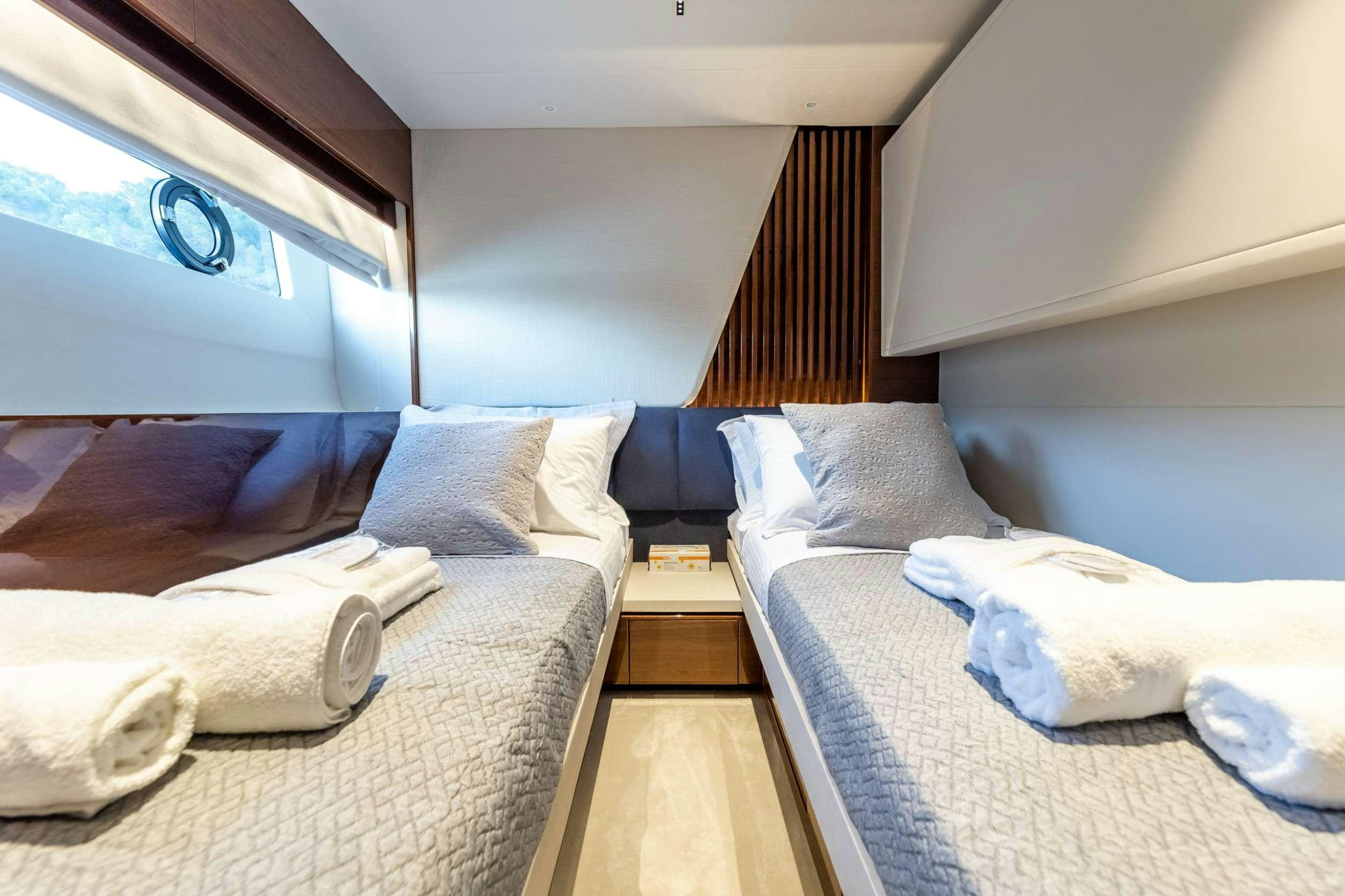 a room with beds and a wood floor aboard VISTA Yacht for Charter
