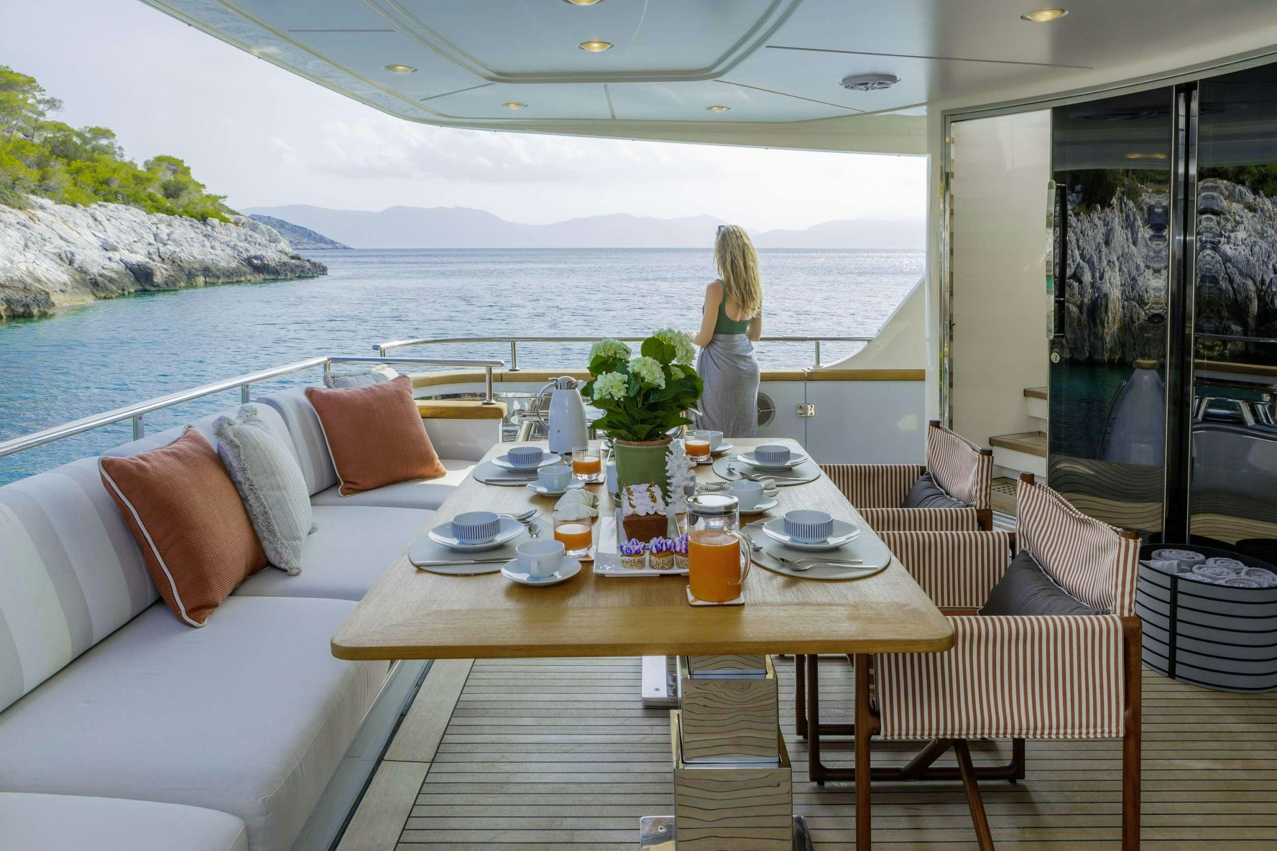 a person standing on a balcony overlooking a body of water aboard ELYSIUM Yacht for Charter