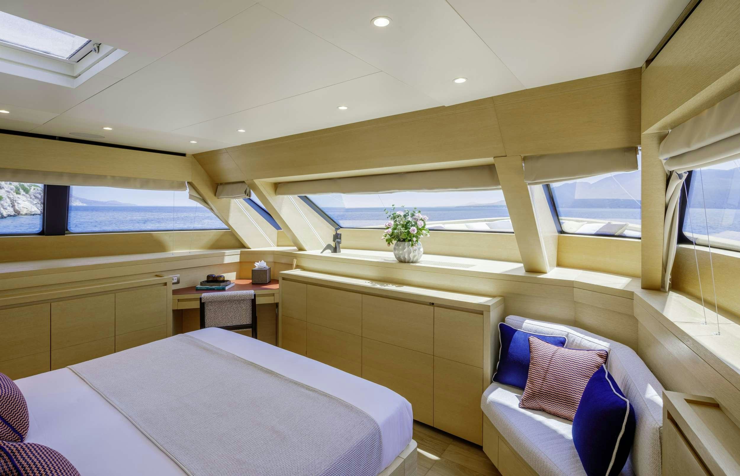 a room with a bed and a desk aboard ELYSIUM Yacht for Charter