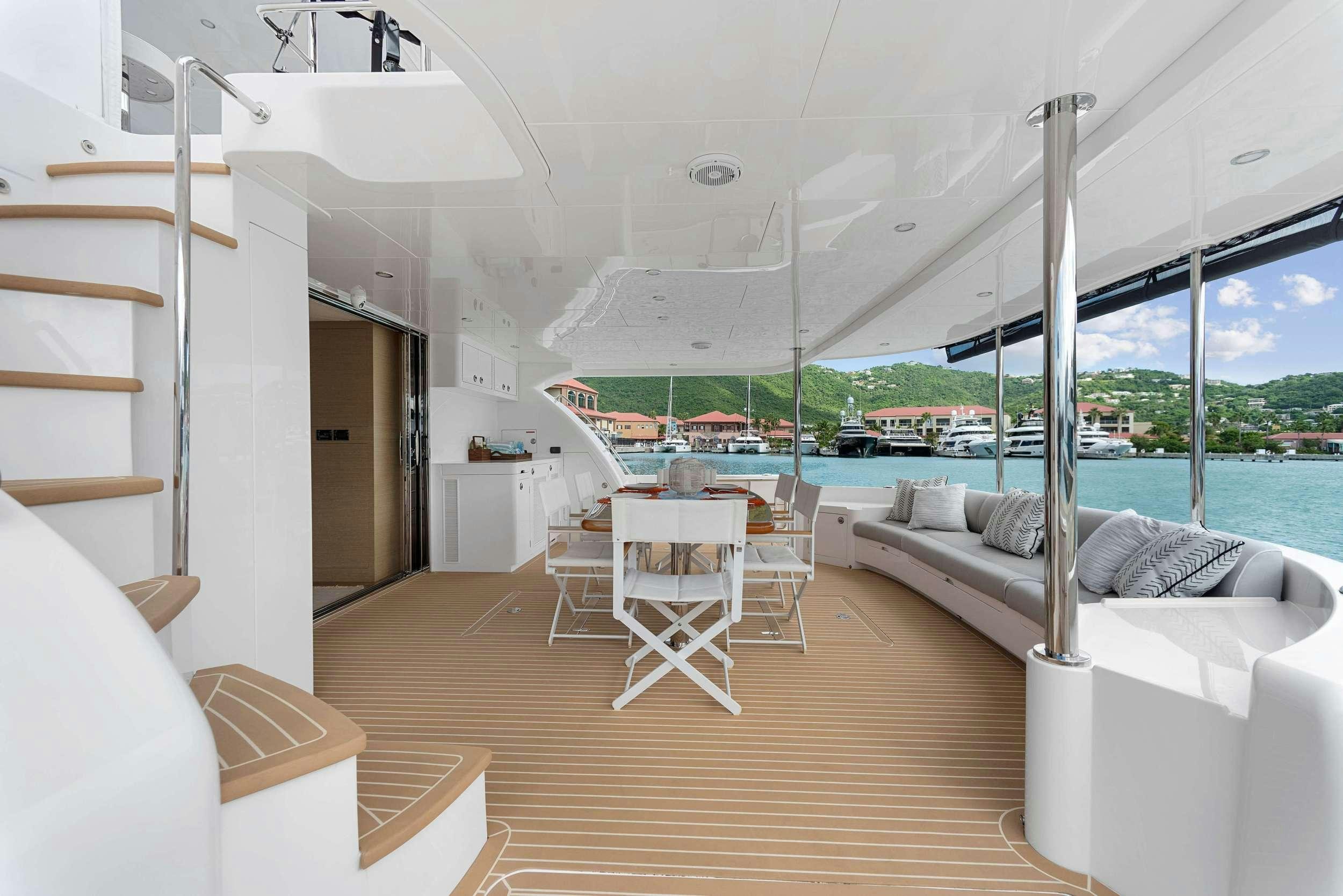 a room with a wood floor and white furniture and a large window aboard SALUS Yacht for Charter