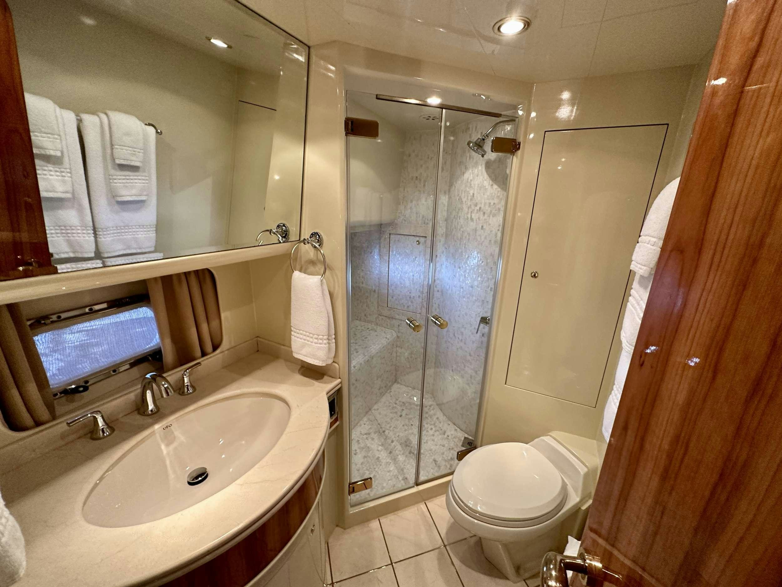 a bathroom with a glass shower aboard QARA Yacht for Charter