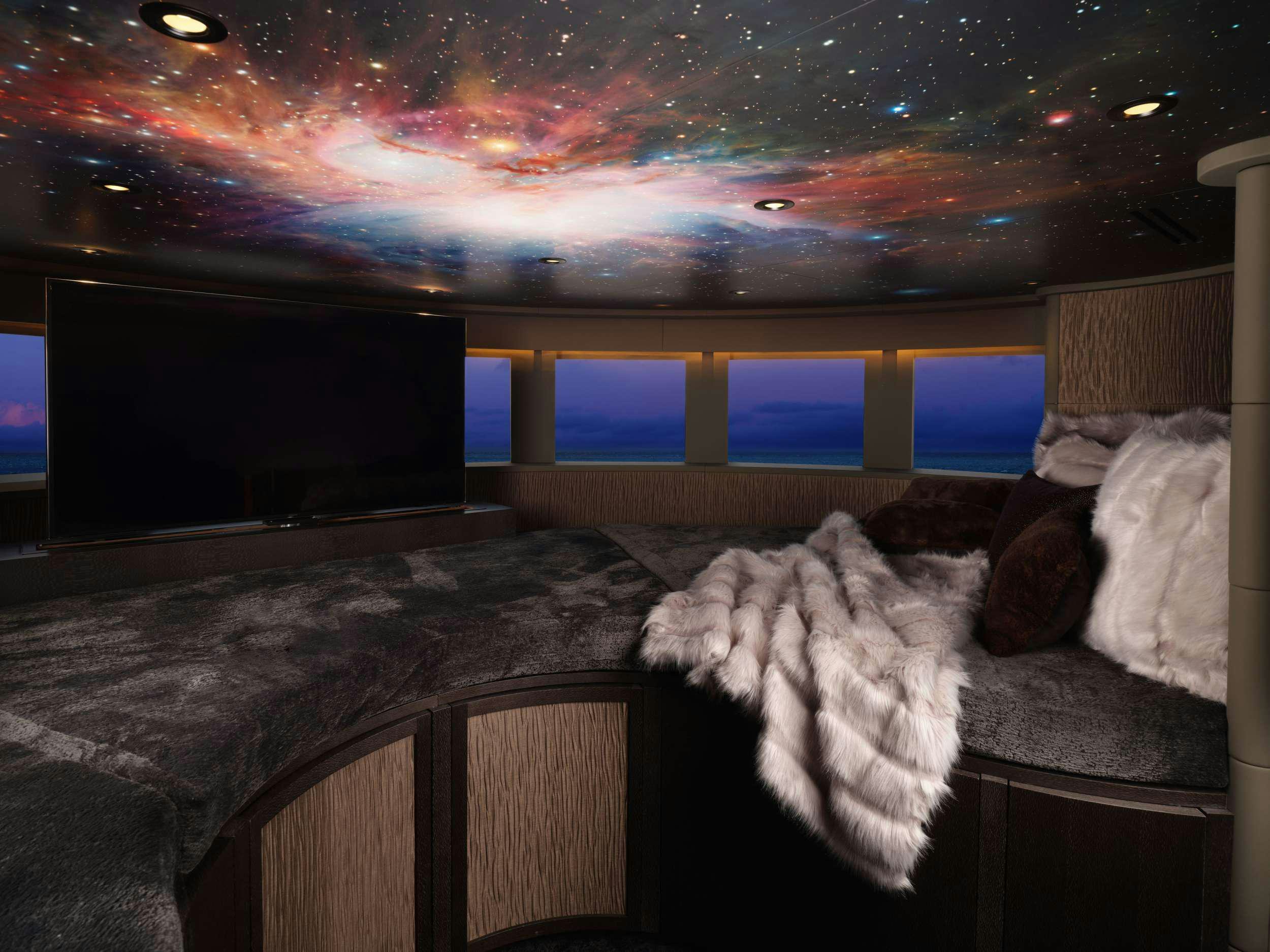 a room with a bed and a television aboard GALAXY Yacht for Charter