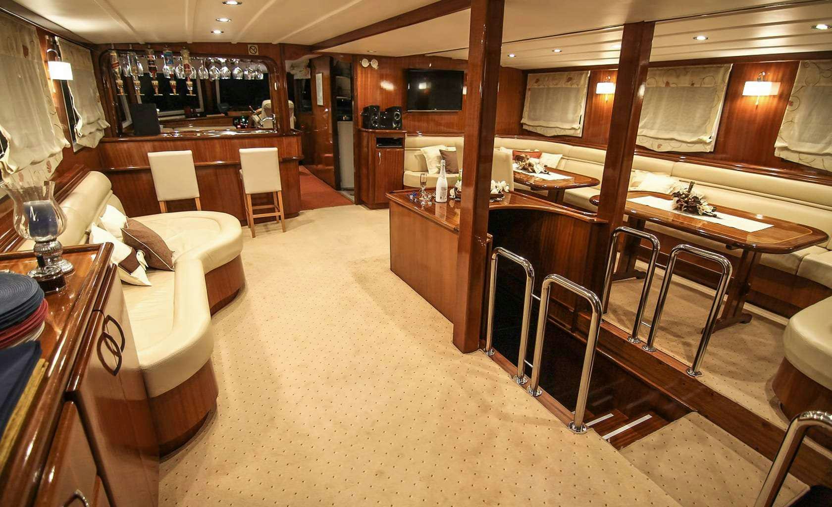 a room with a bar and chairs aboard AURUM Yacht for Charter