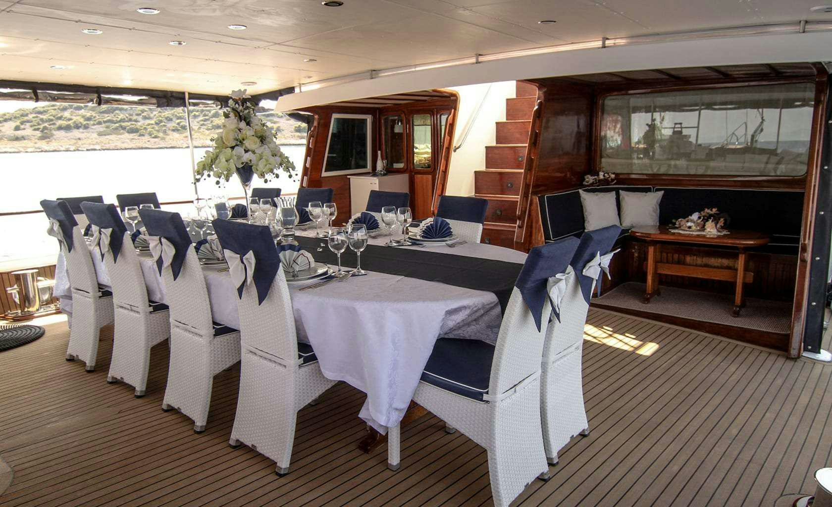a room with tables and chairs aboard AURUM Yacht for Charter