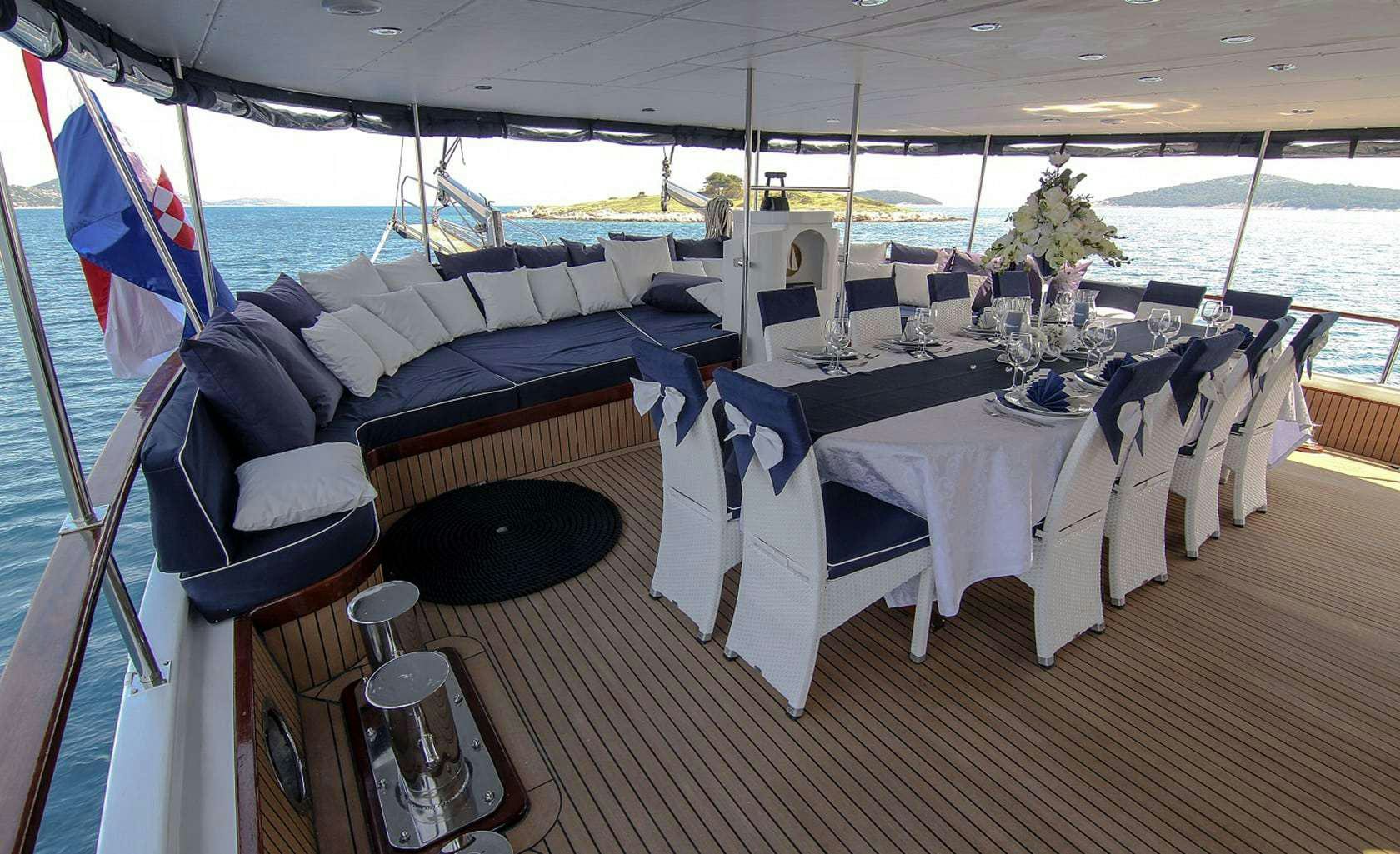 a boat with white tables and chairs aboard AURUM Yacht for Charter