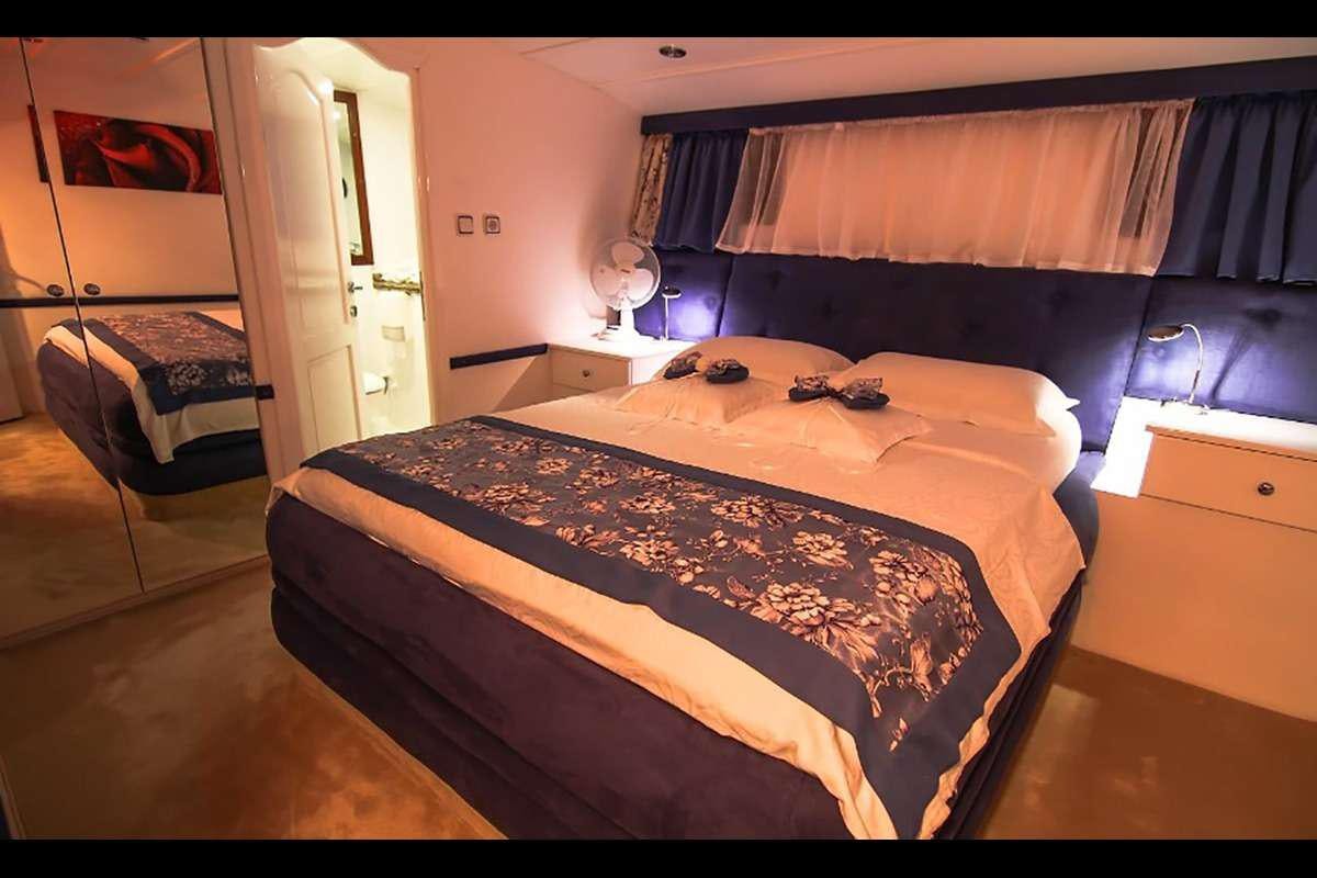 a bedroom with a large bed aboard AURUM Yacht for Charter