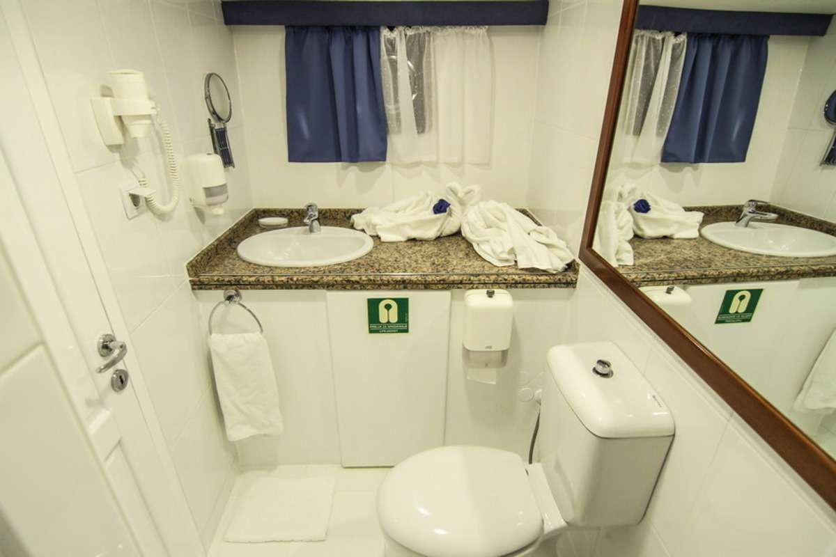 a bathroom with a sink toilet and a mirror aboard AURUM Yacht for Charter