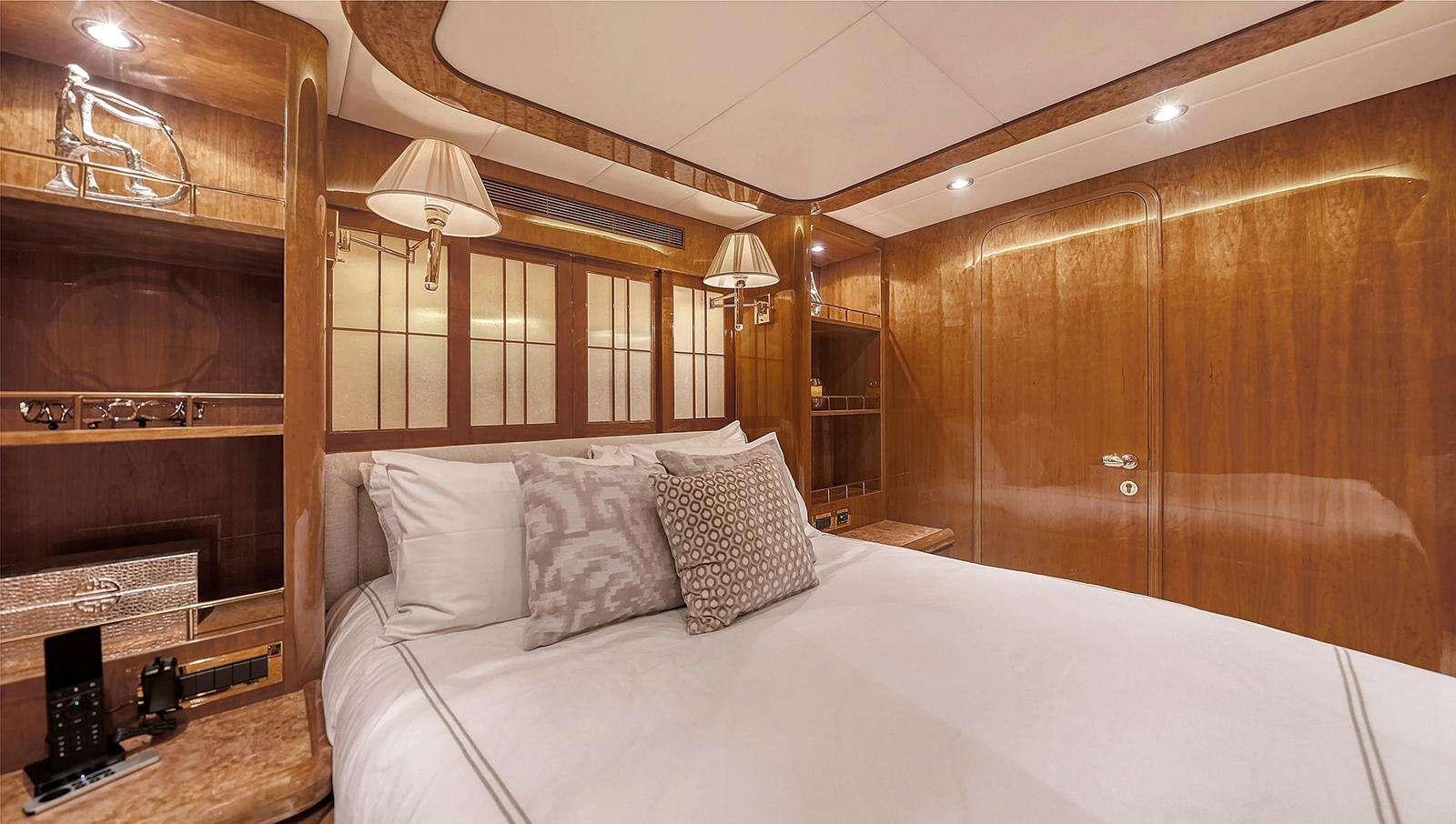 a bed with pillows and a fireplace aboard FANTASEA Yacht for Charter