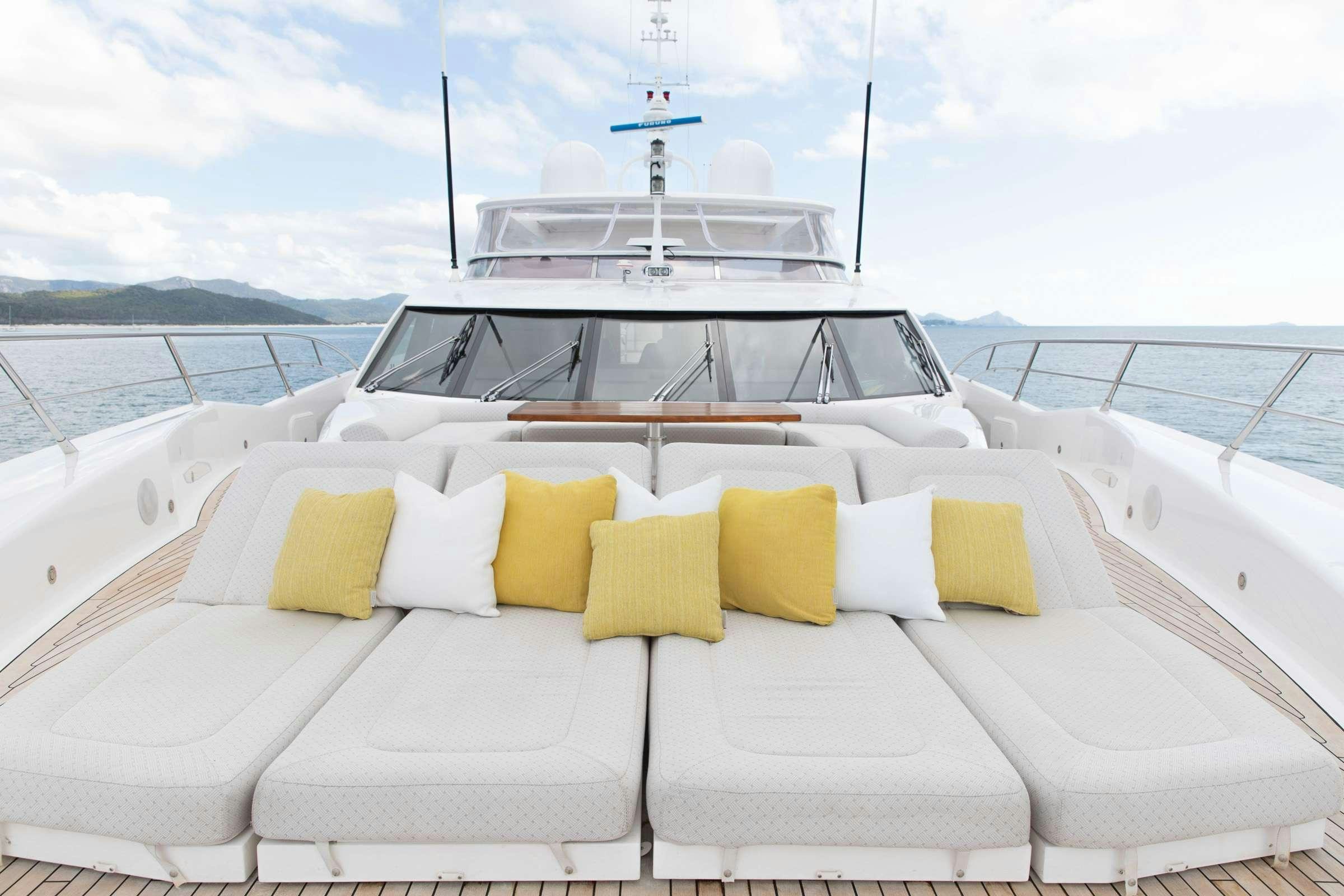a white boat with yellow pillows on a boat aboard RASCAL Yacht for Charter