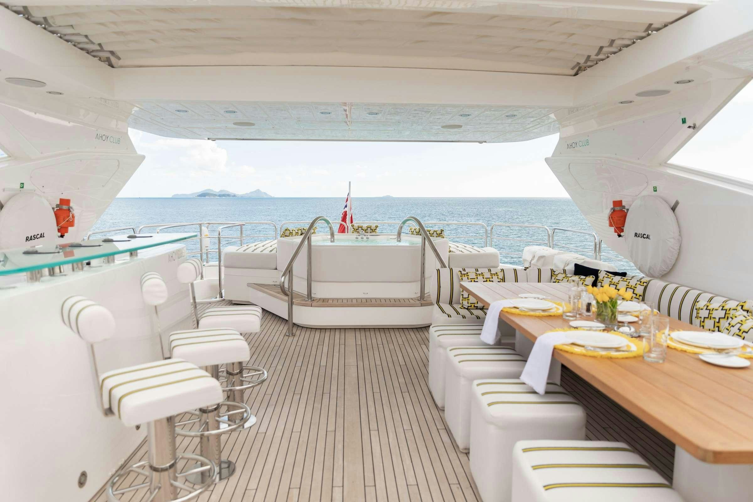 a room with a table chairs and a large white bed aboard RASCAL Yacht for Charter