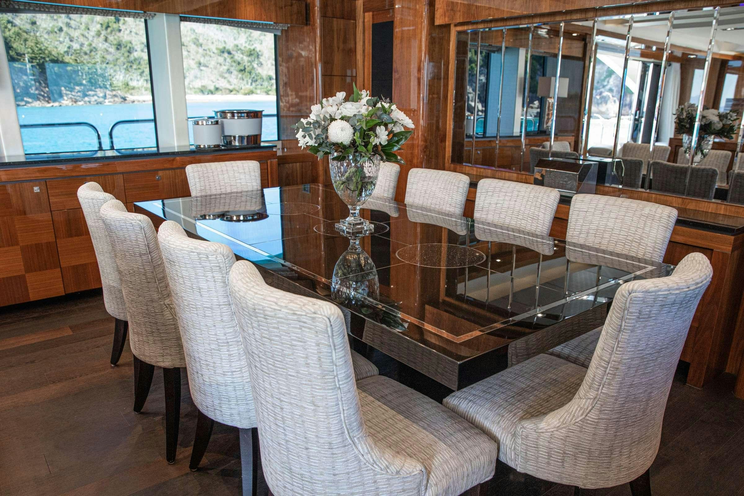 a dining room with chairs and a vase of flowers aboard RASCAL Yacht for Charter
