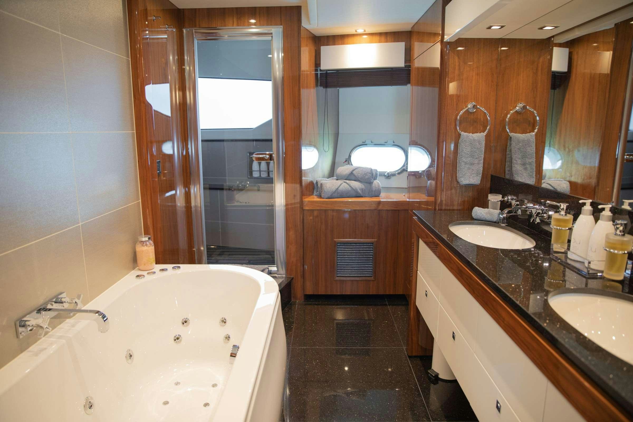 a bathroom with a bathtub sink and a mirror aboard RASCAL Yacht for Charter