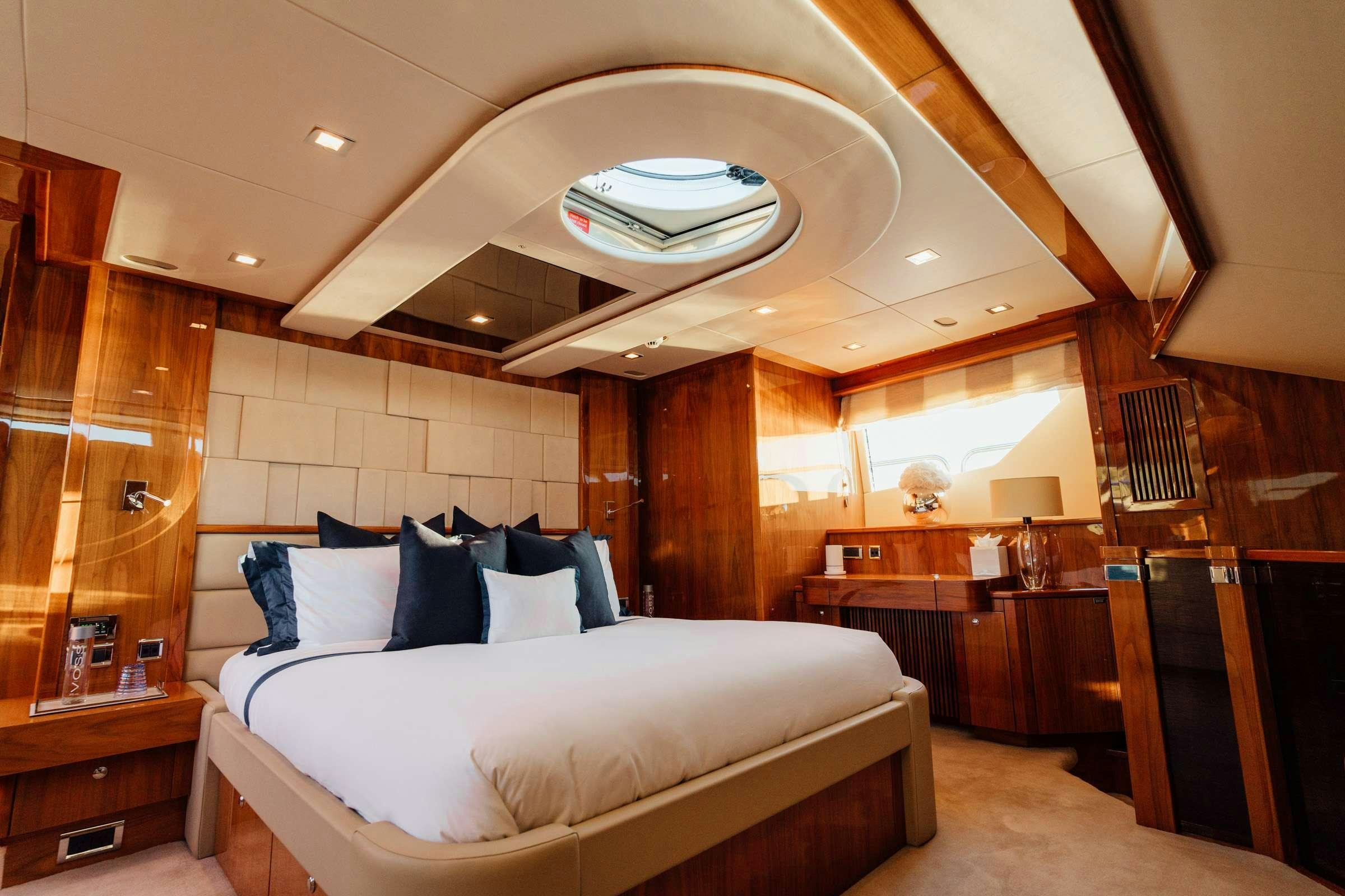 a bedroom with a bed and a wood wall aboard CHAOS Yacht for Charter