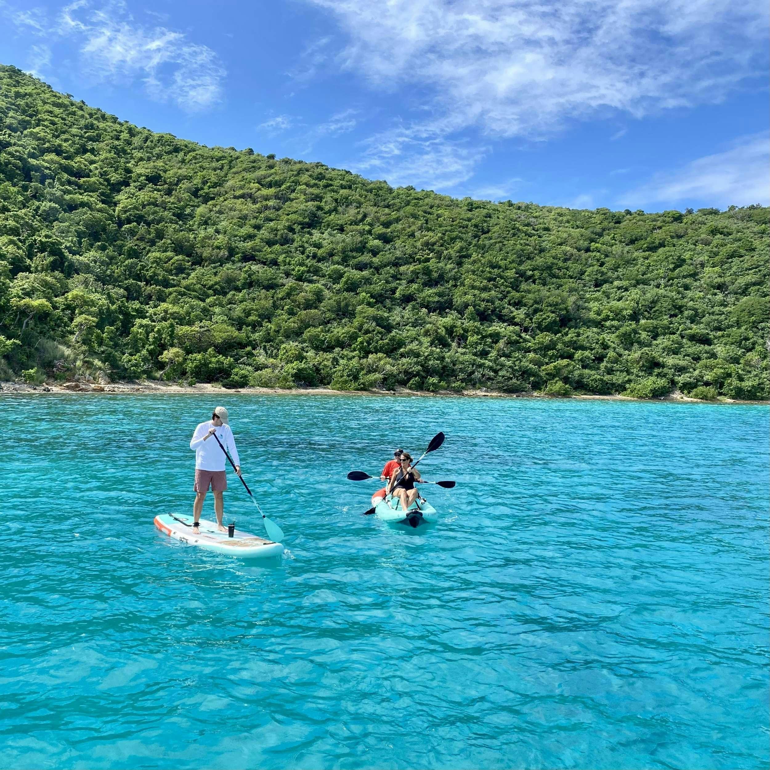 a couple of people on paddle boats in the water aboard SOME KIND OF WONDERFUL Yacht for Charter