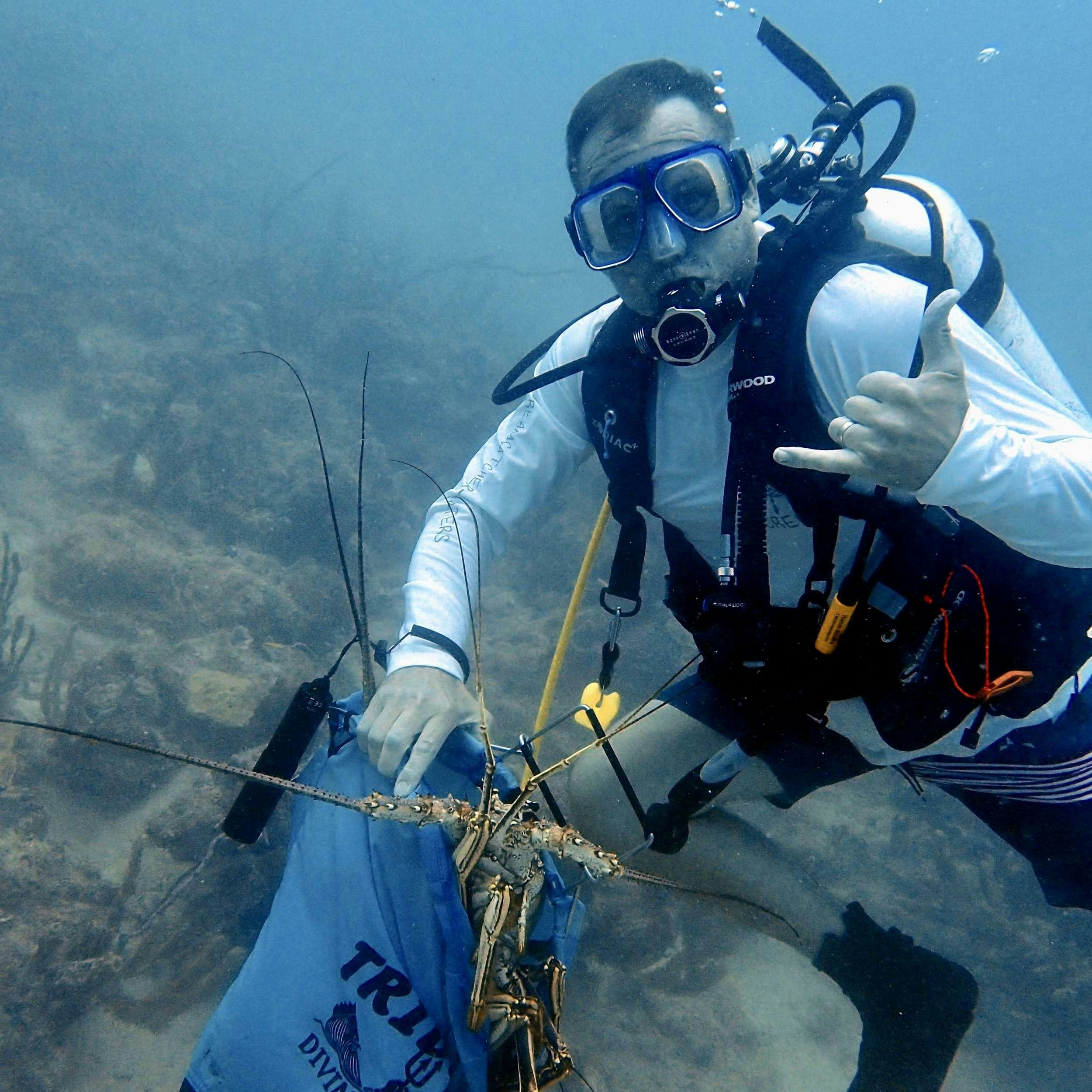 a man in a space suit holding a fish aboard SOME KIND OF WONDERFUL Yacht for Charter