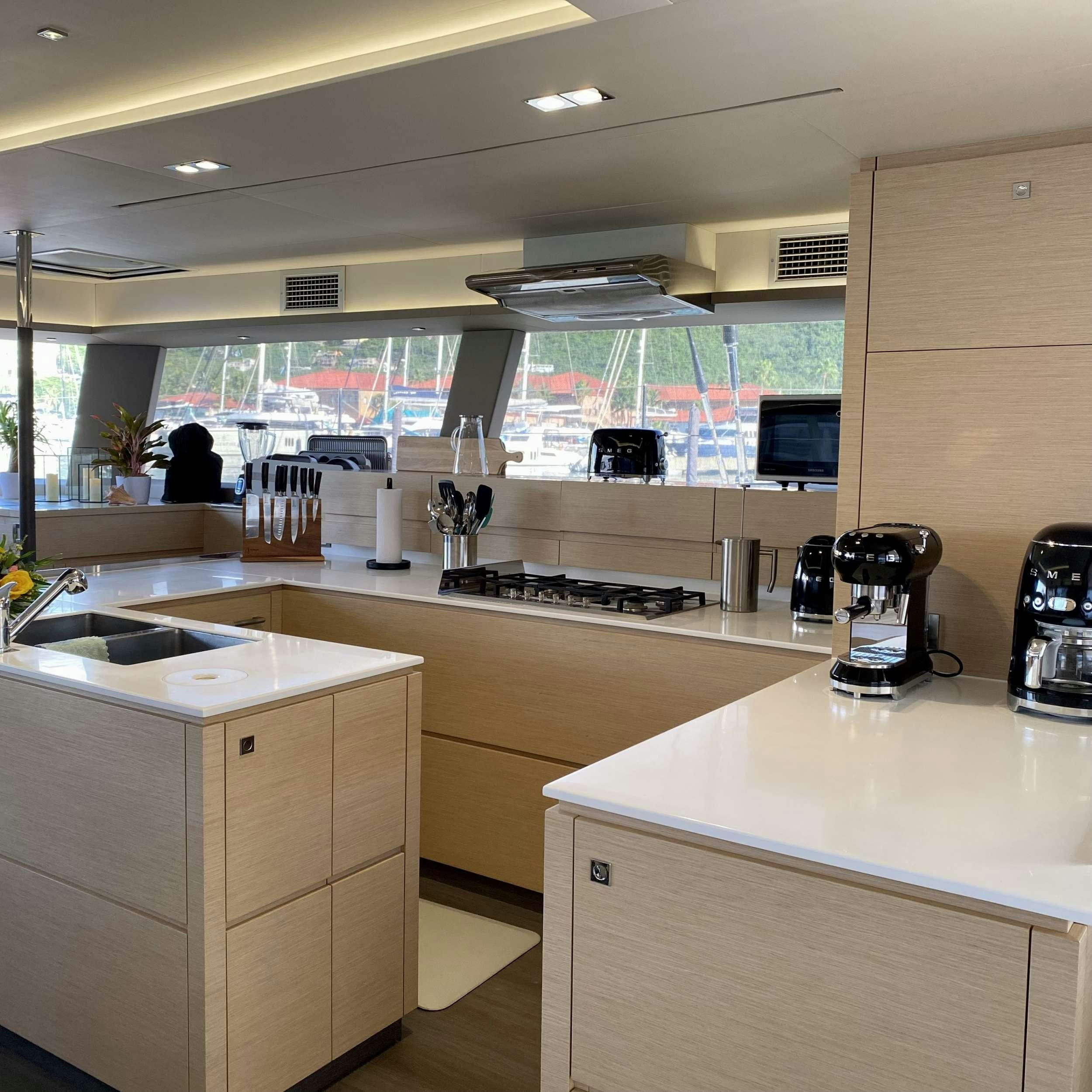 a kitchen with a countertop sink and a large window aboard SOME KIND OF WONDERFUL Yacht for Charter