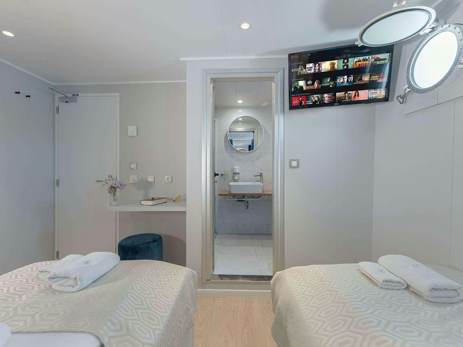 a bedroom with a bed and a mirror aboard BELLEZZA Yacht for Charter