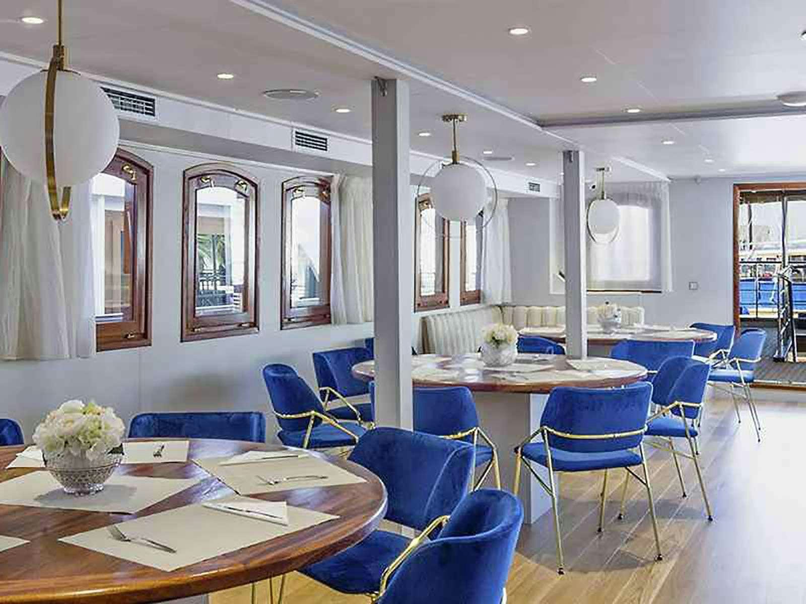 a room with tables and chairs aboard BELLEZZA Yacht for Charter