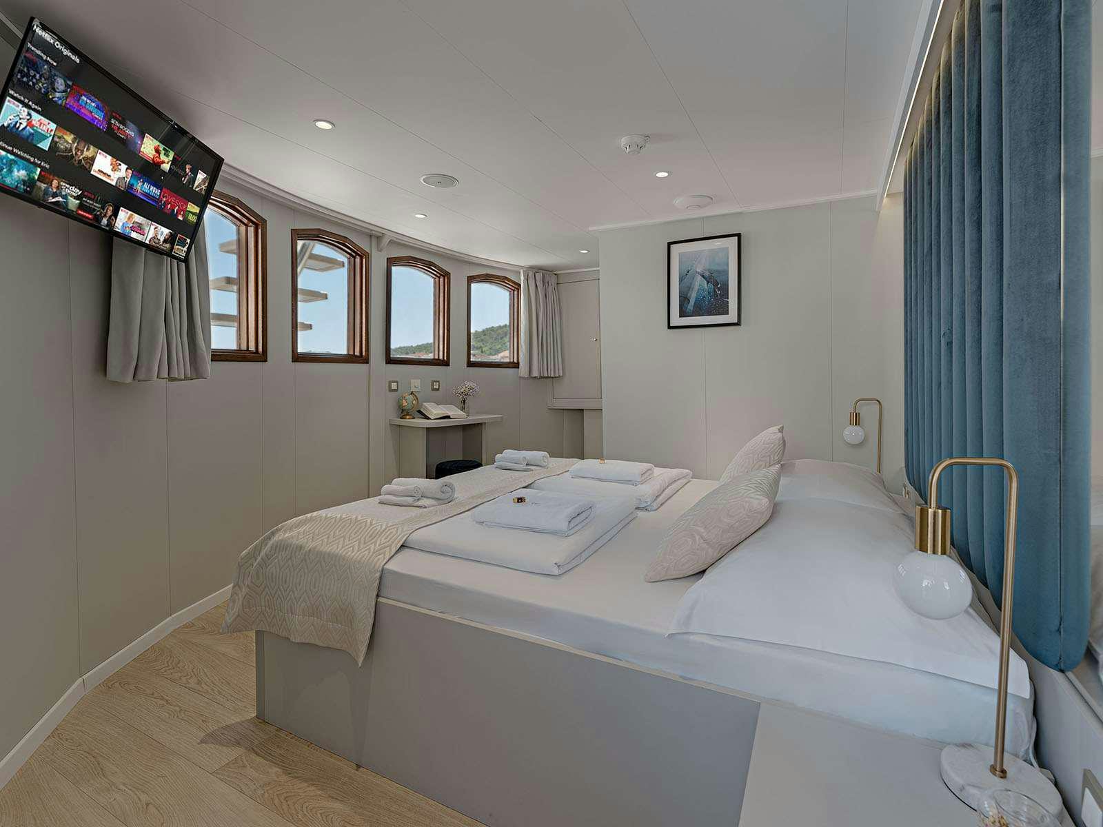 a room with a bed and a television aboard BELLEZZA Yacht for Charter