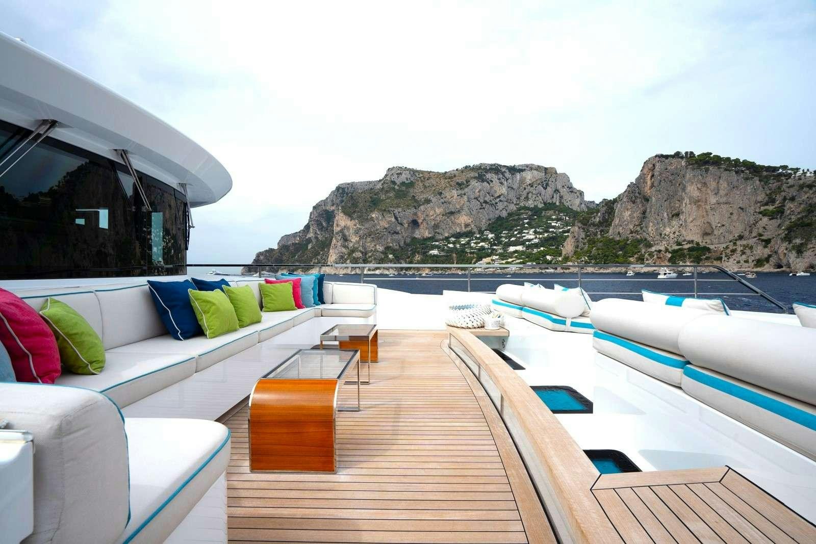 a deck with a view of the ocean and mountains aboard HALARA Yacht for Charter