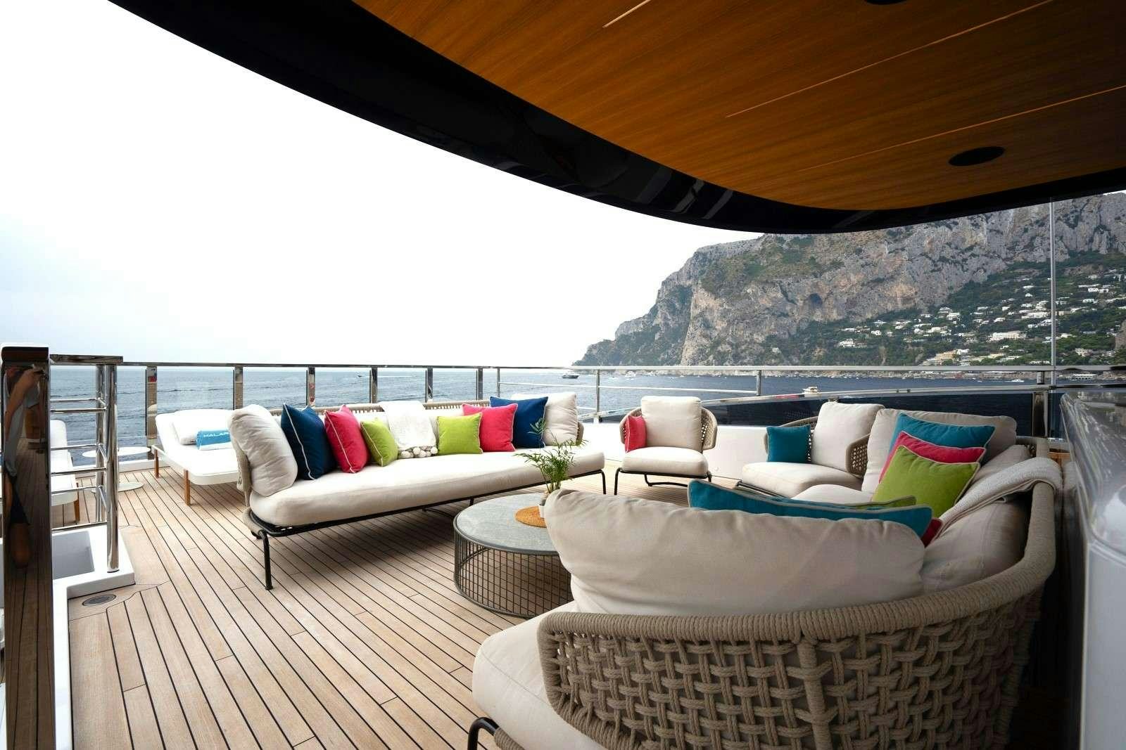 a large white couch and a table on a deck aboard HALARA Yacht for Charter
