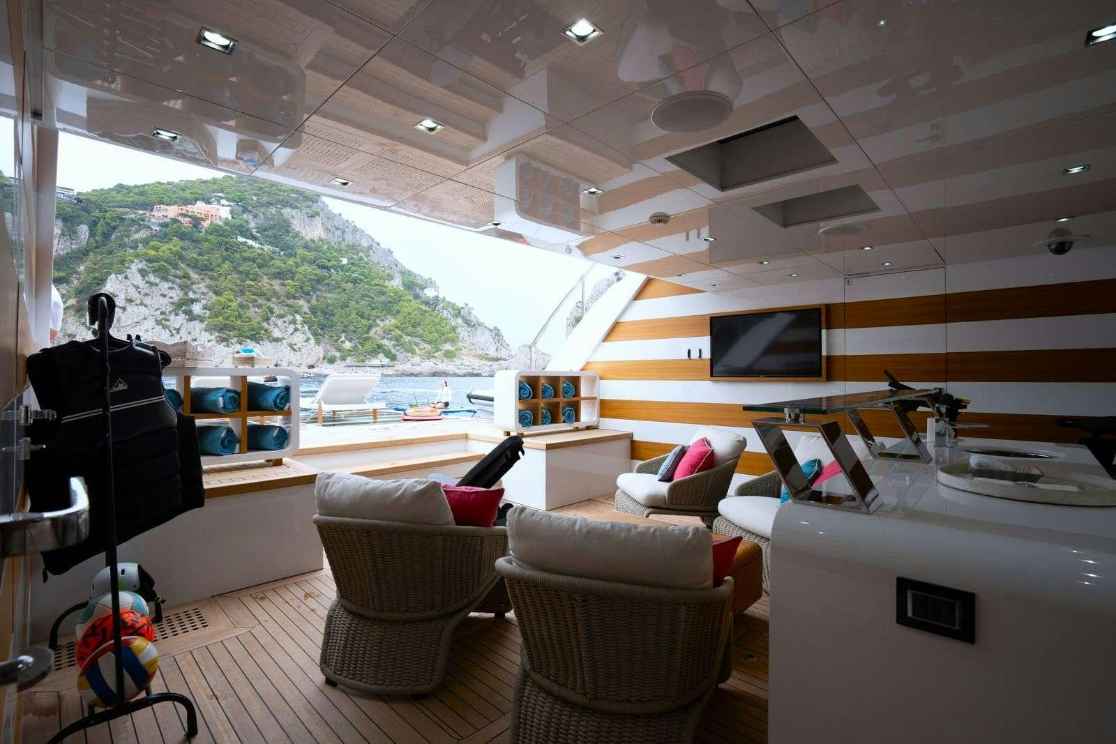 a room with a large window and a couch and a guitar aboard HALARA Yacht for Charter