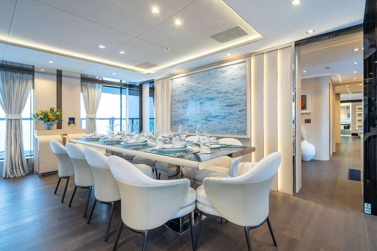 a large room with white chairs and a table aboard HALARA Yacht for Charter