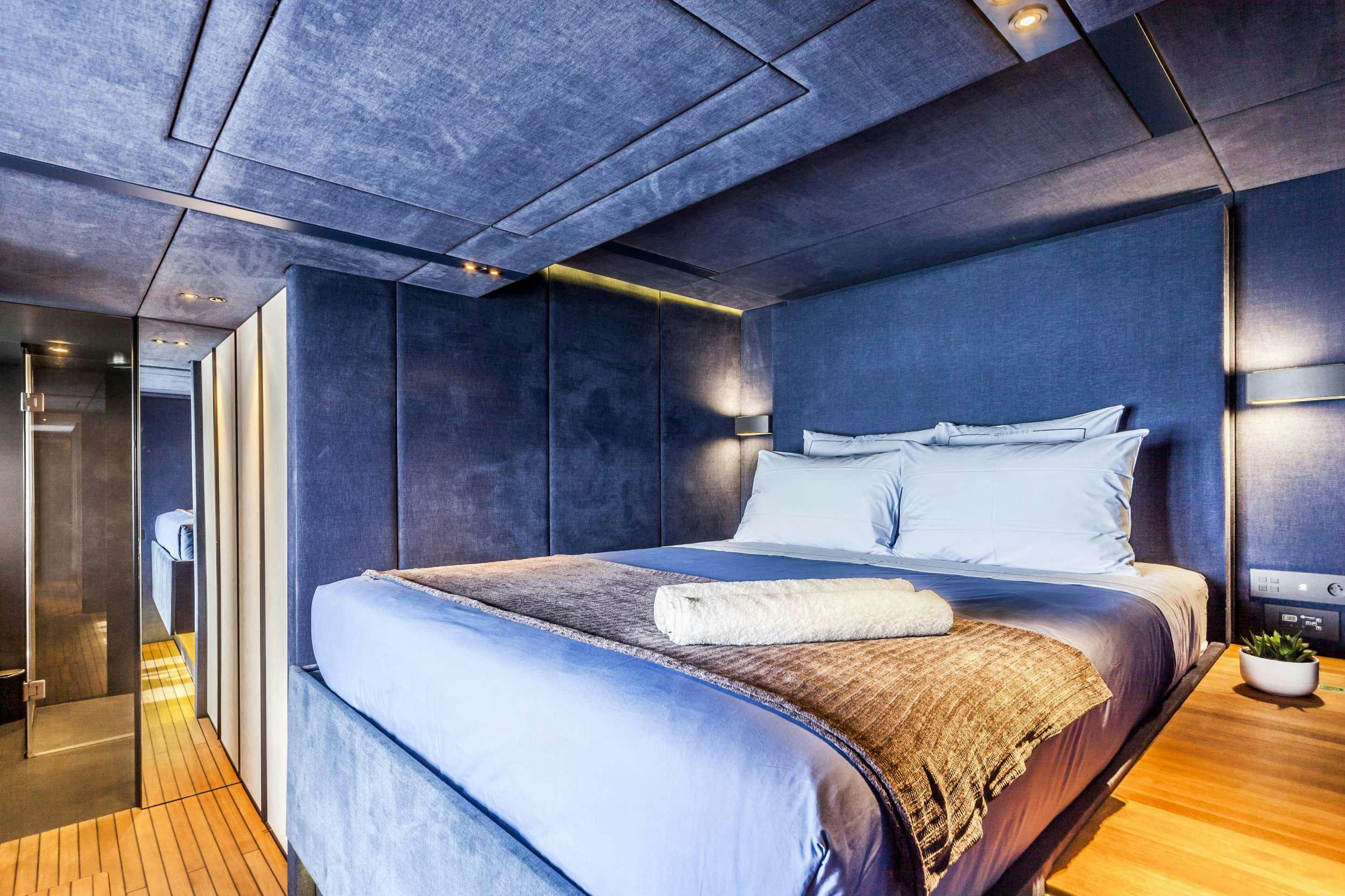 a bed with a blue wall aboard MIDORI Yacht for Charter