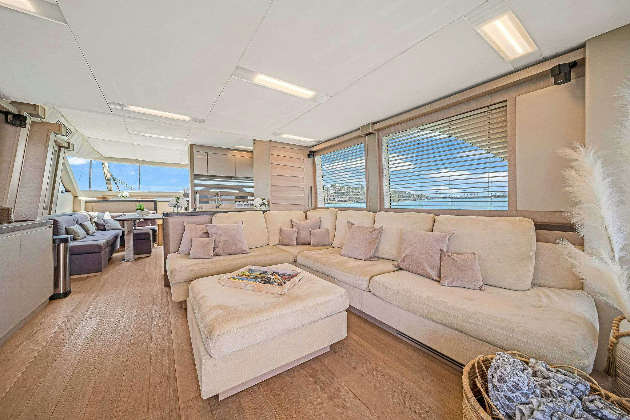 a living room with a couch and a large window aboard VOLO Yacht for Charter