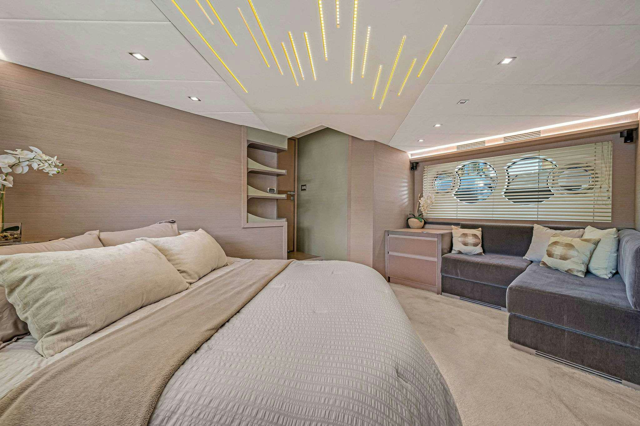 a bedroom with a bed and a couch aboard VOLO Yacht for Charter