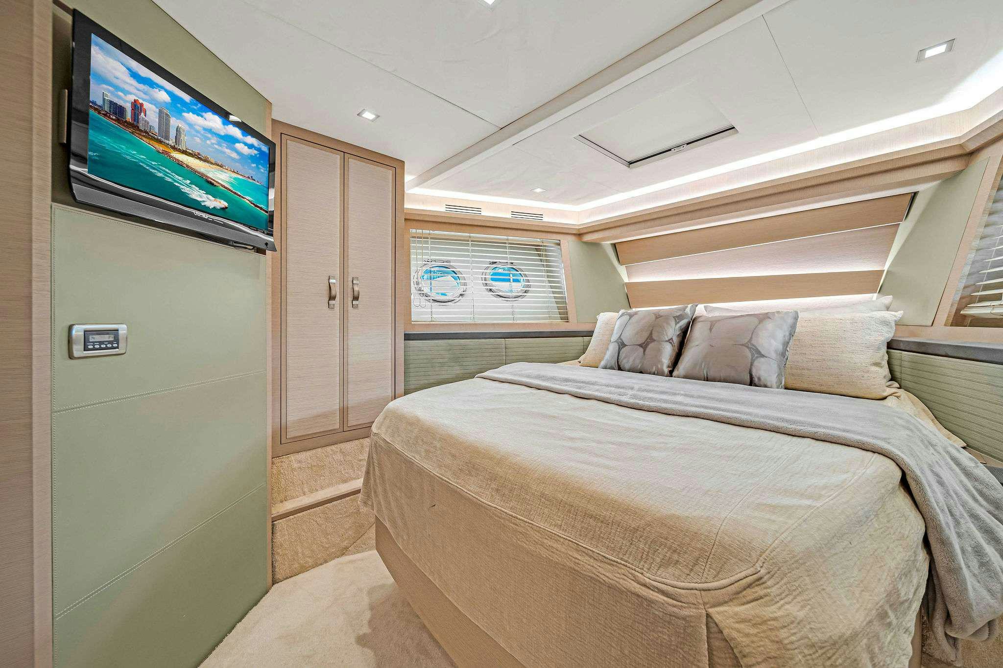 a bedroom with a bed and a tv on the wall aboard VOLO Yacht for Charter