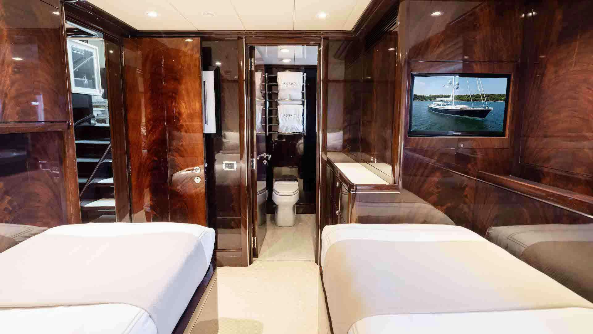 a room with a bed and a television aboard ANEMOI Yacht for Charter