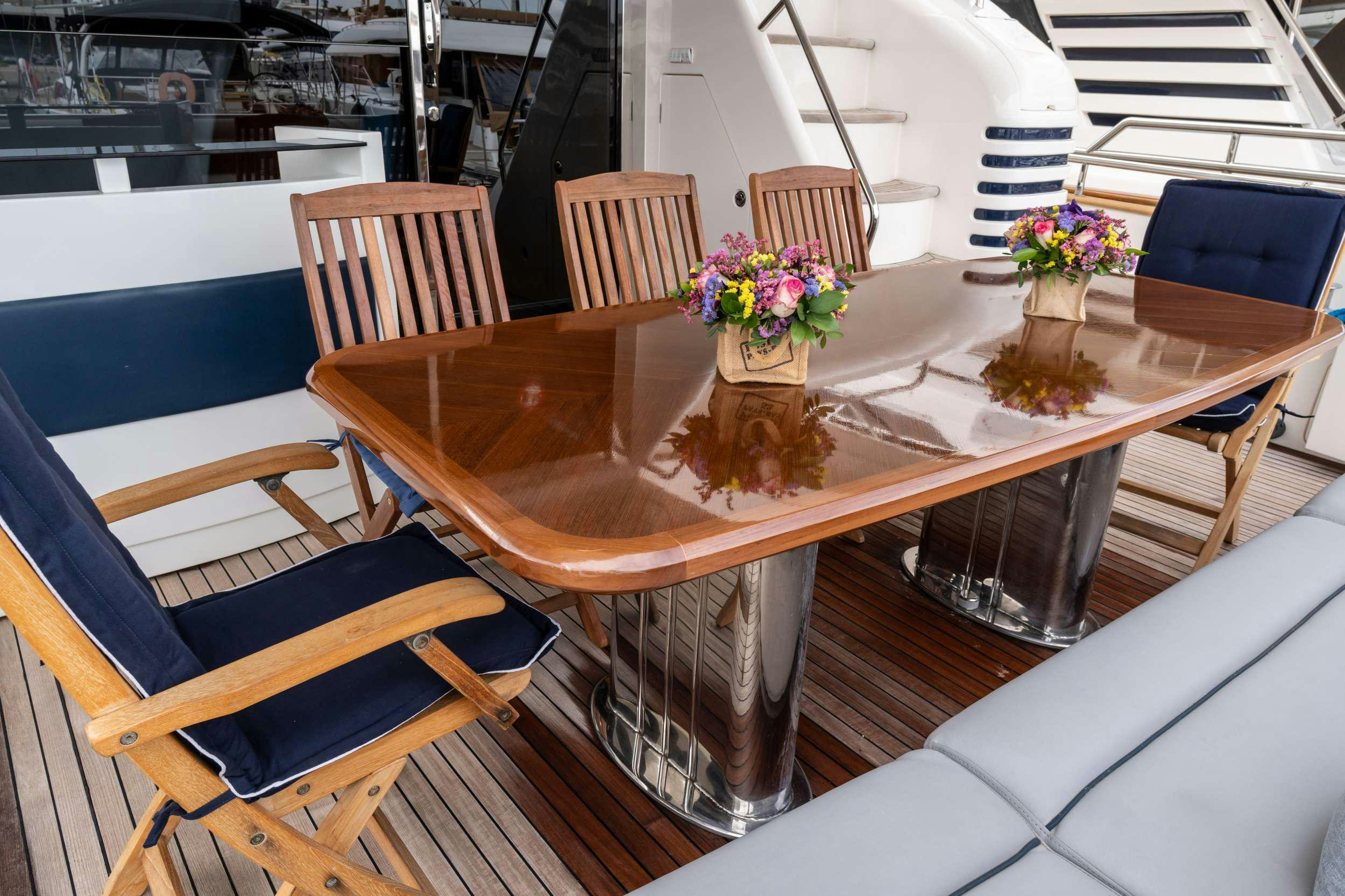 a table with chairs and a vase of flowers on it aboard GEKTOR Yacht for Charter