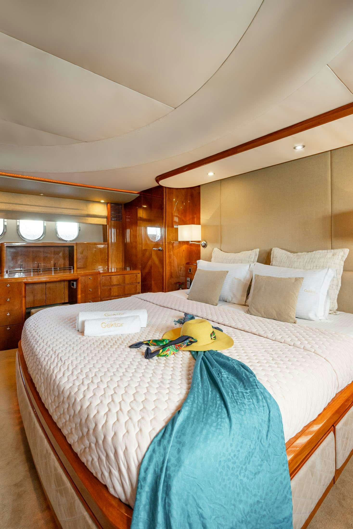 a bed with a blue blanket and a stuffed toy on it aboard GEKTOR Yacht for Charter