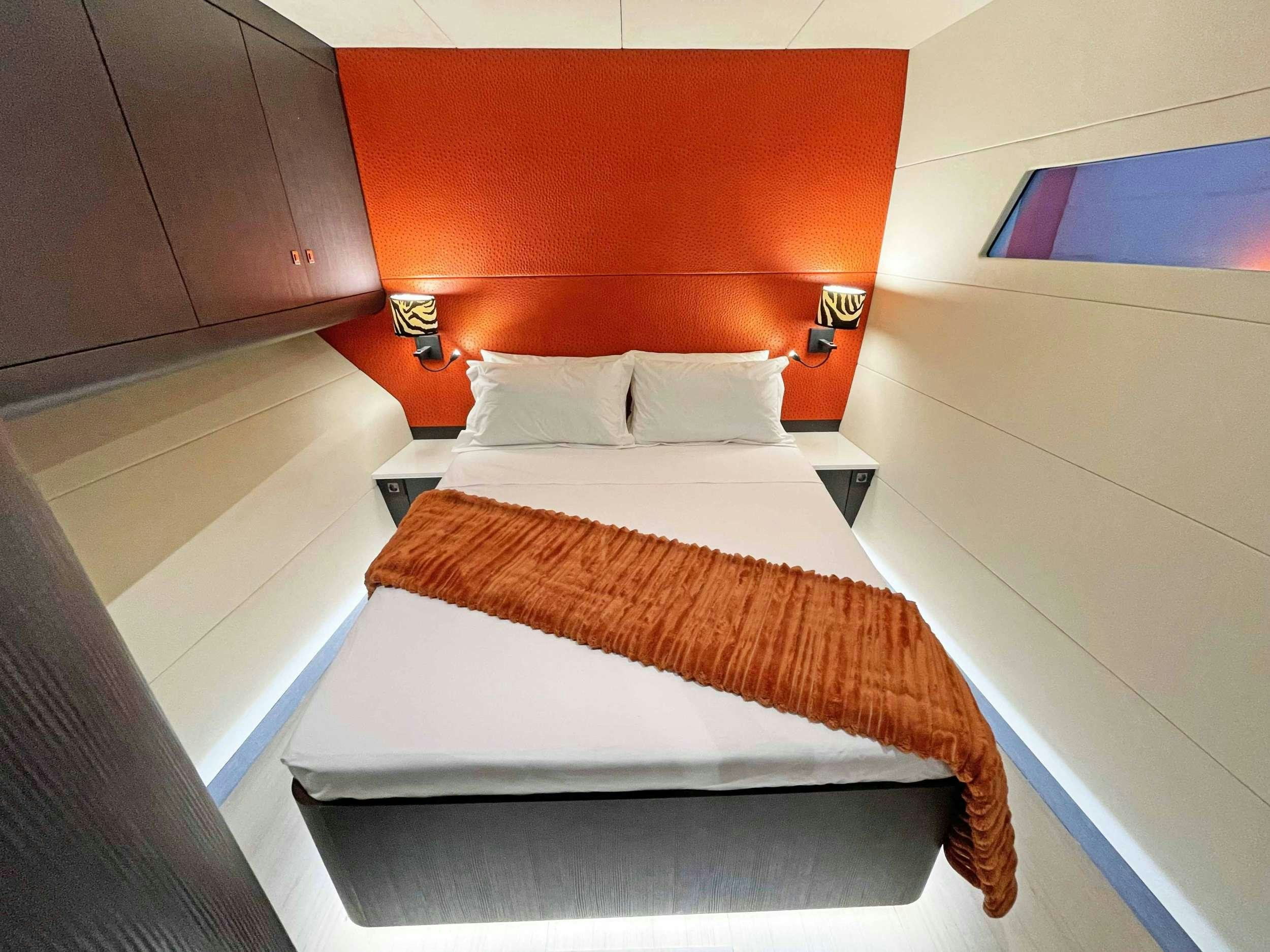 a bed with orange pillows aboard SKYE Yacht for Charter
