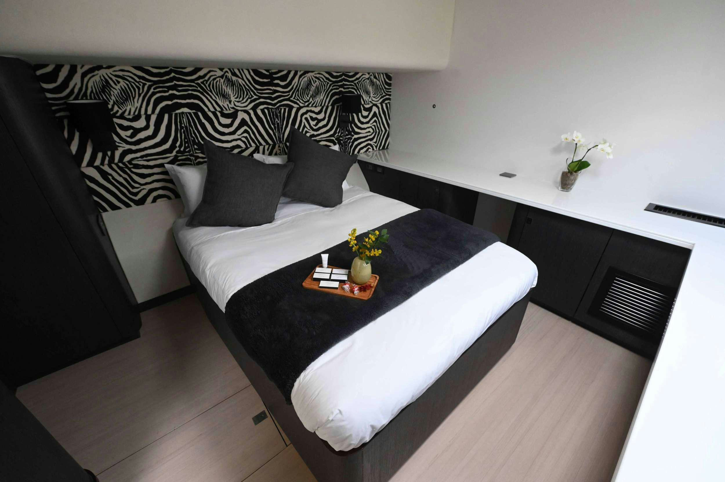 a bed with a black headboard aboard SKYE Yacht for Charter