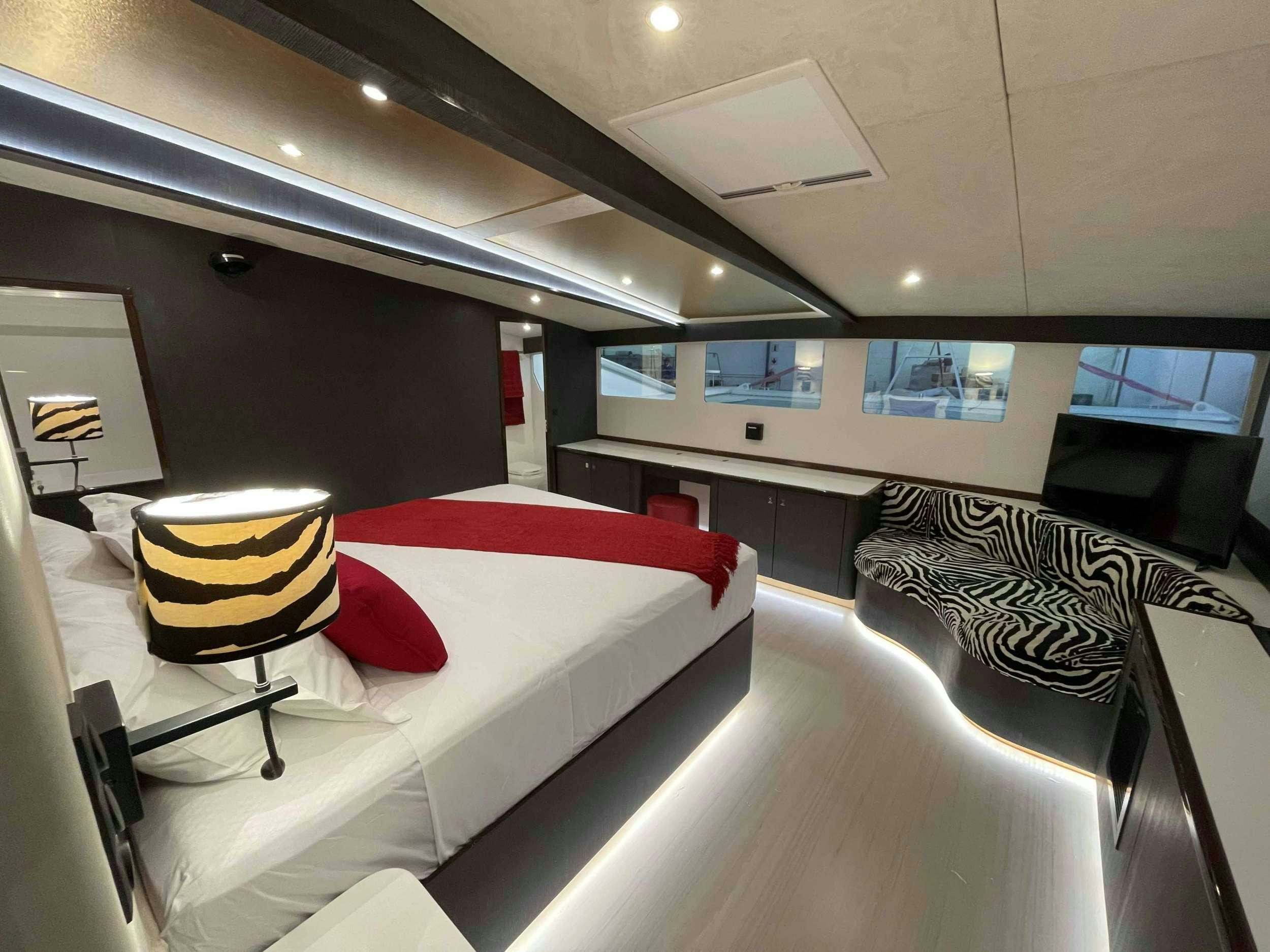 a room with a bed and a chair aboard SKYE Yacht for Charter