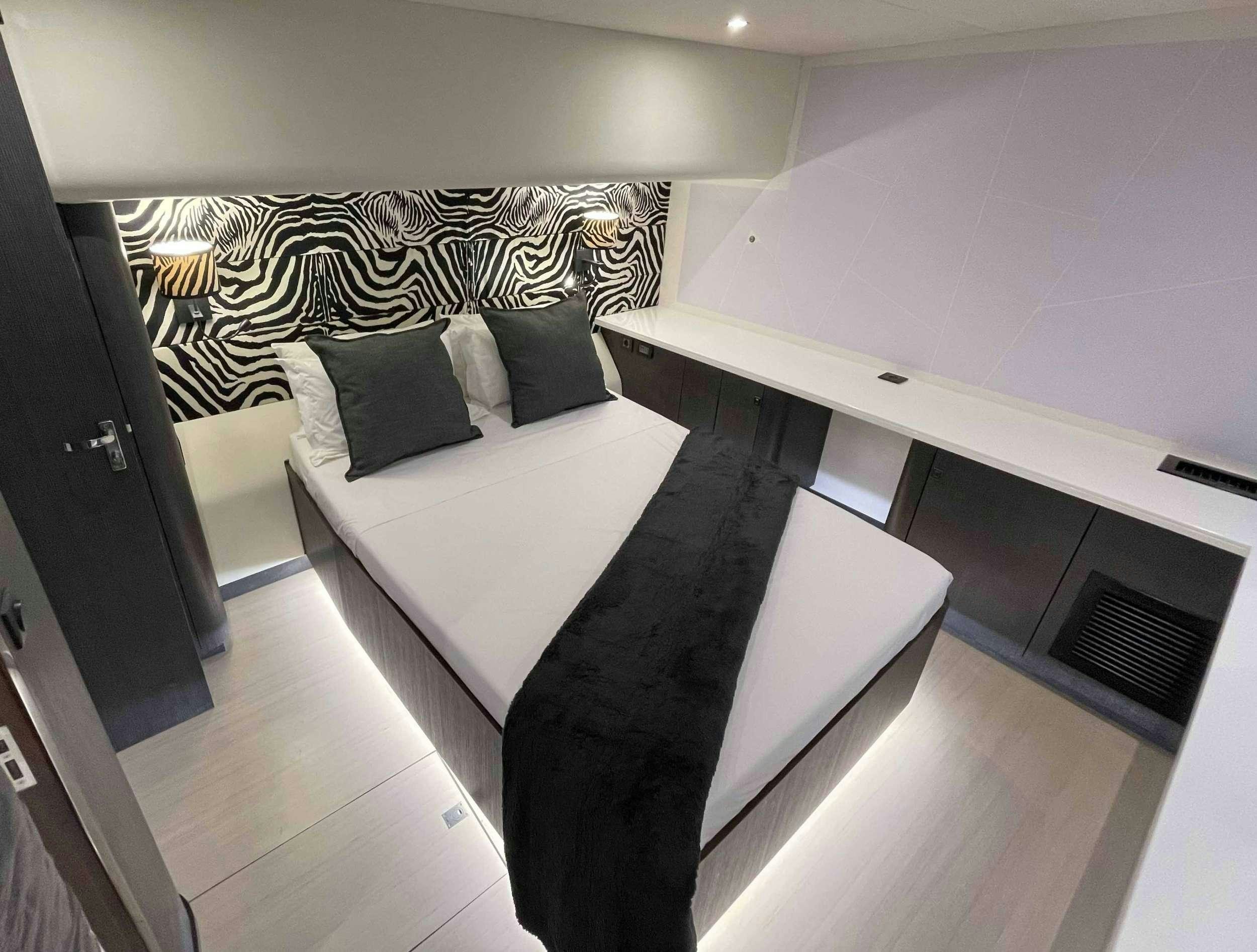 a room with a bed and a desk aboard SKYE Yacht for Charter