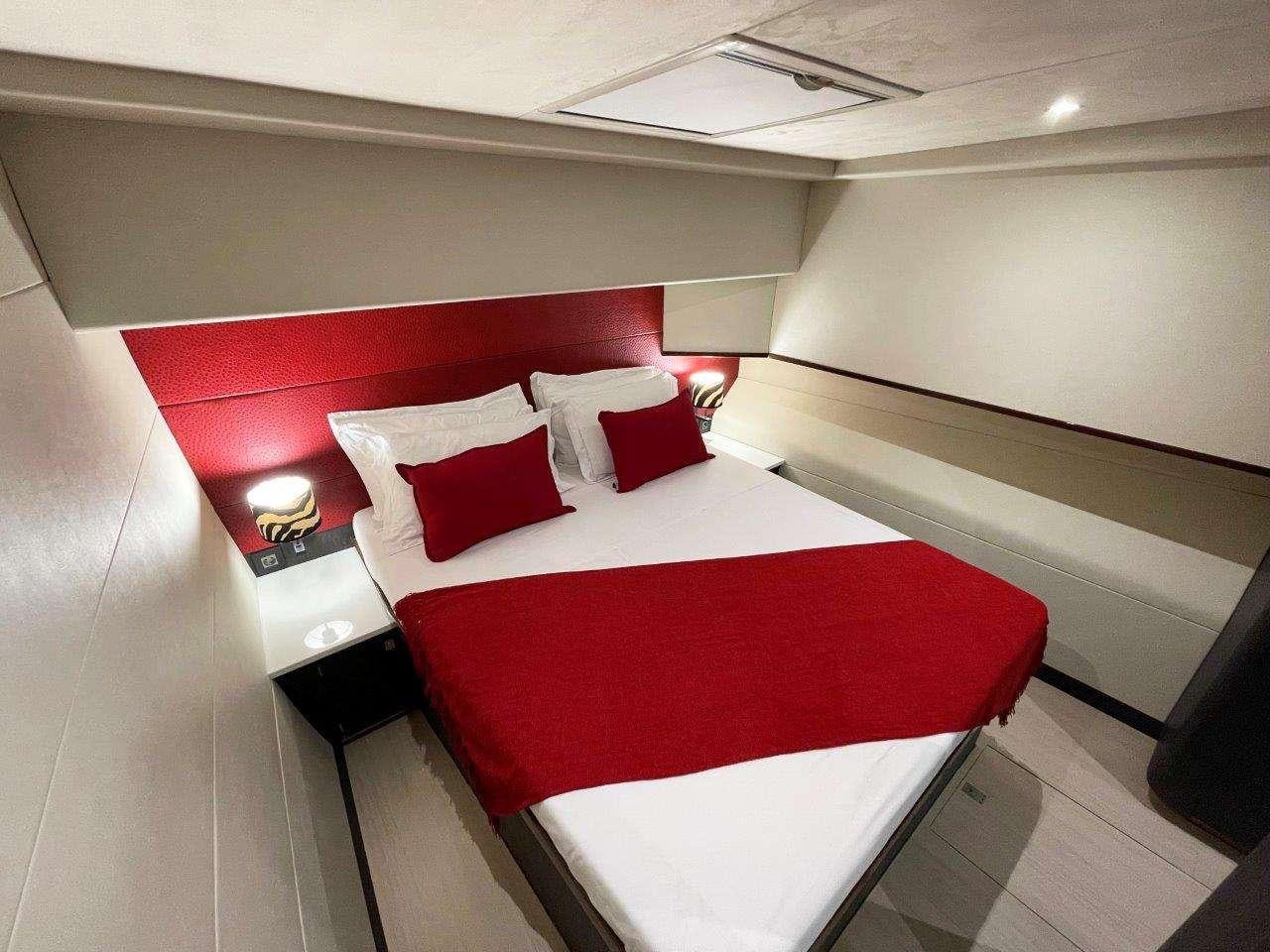 a room with a bed and a red bed aboard SKYE Yacht for Charter