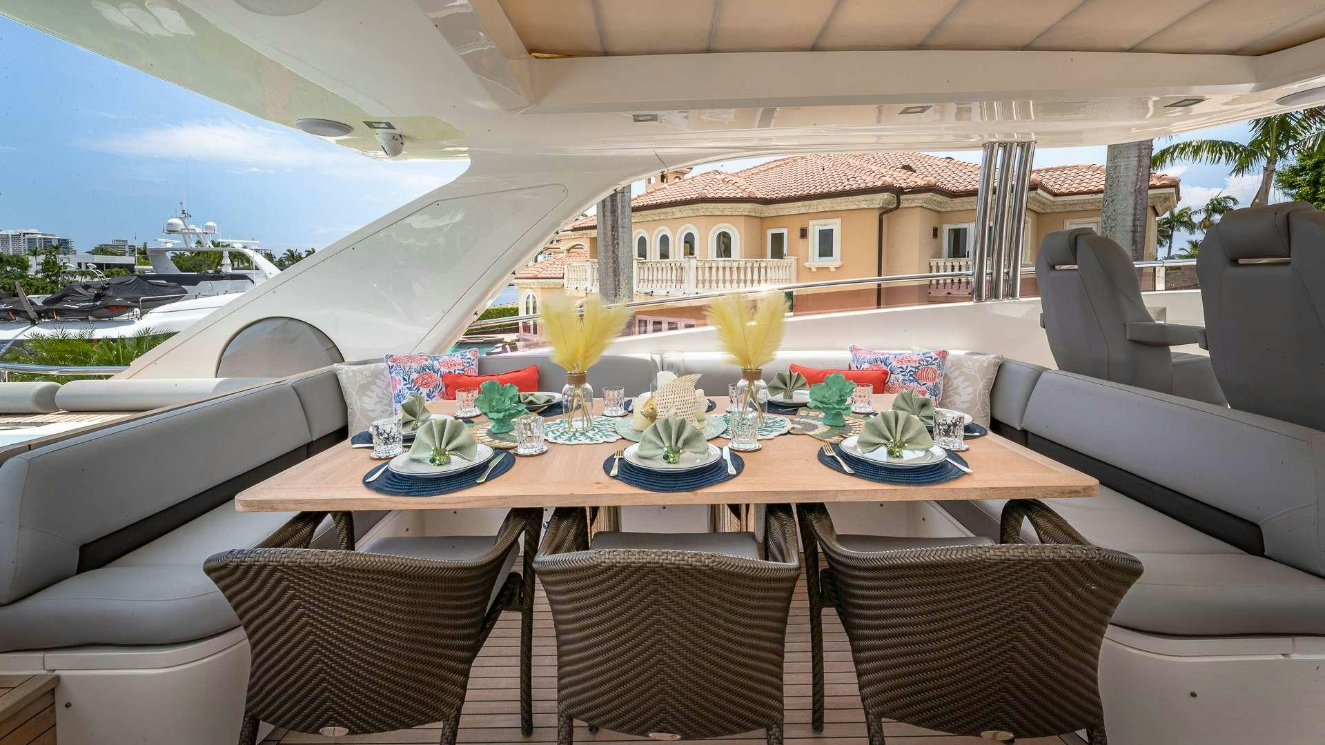 a table with chairs and a glass of juice on it aboard BEACHFRONT II Yacht for Charter