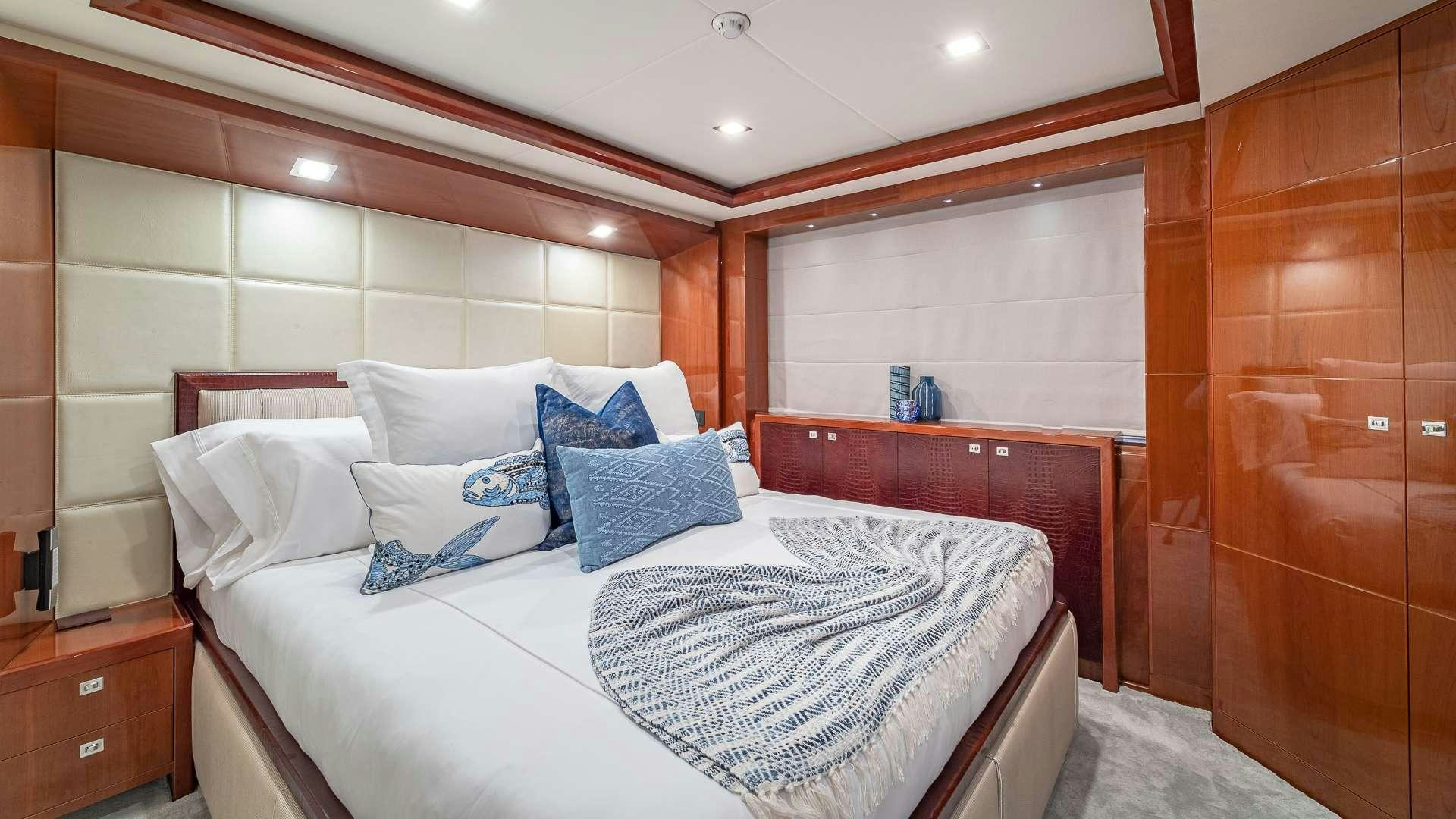 a bed with a white sheet and pillows on it aboard BEACHFRONT II Yacht for Charter