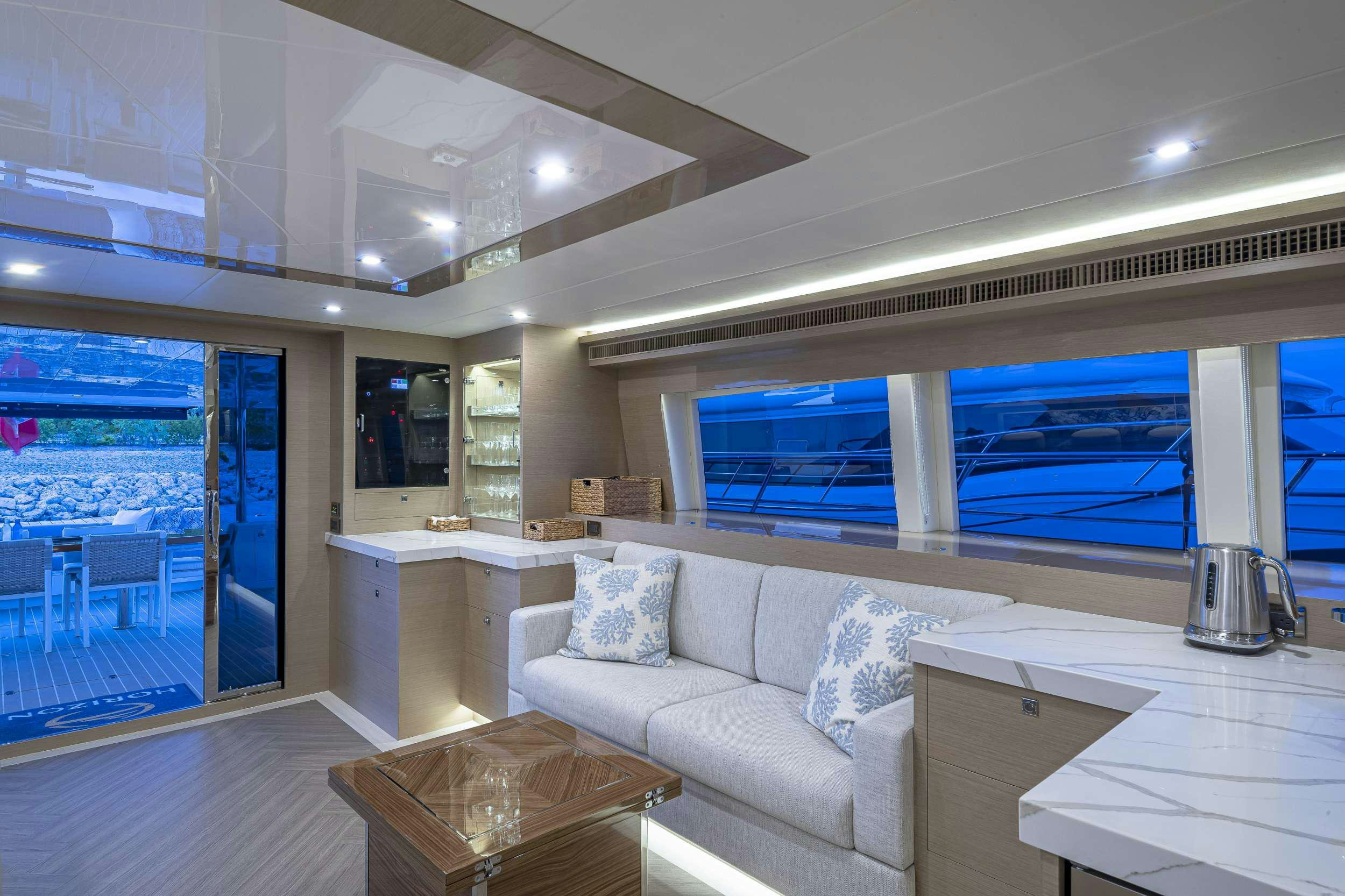 a living room with a large window aboard OMAKASE Yacht for Charter