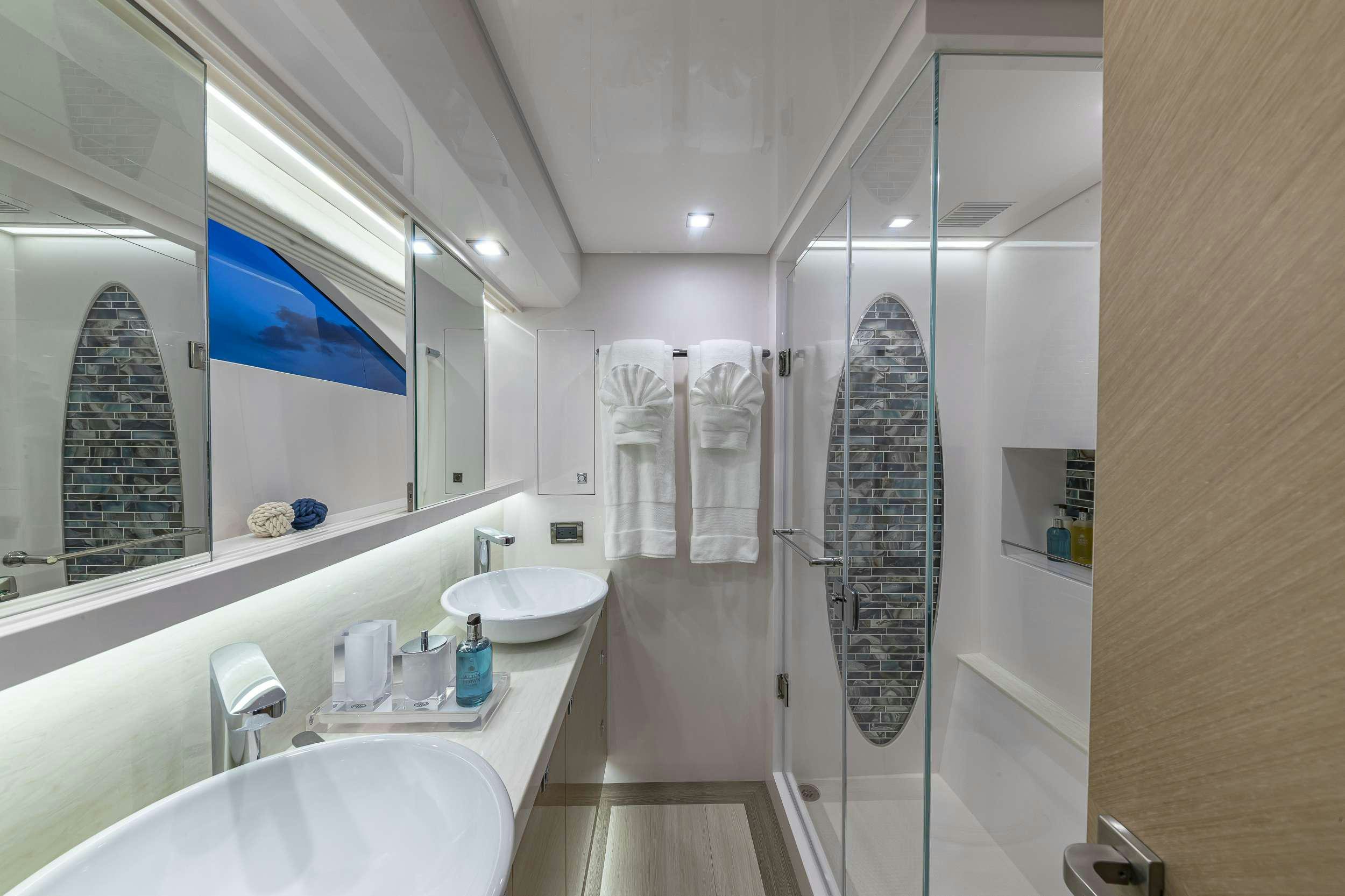 a bathroom with a shower and sink aboard OMAKASE Yacht for Charter
