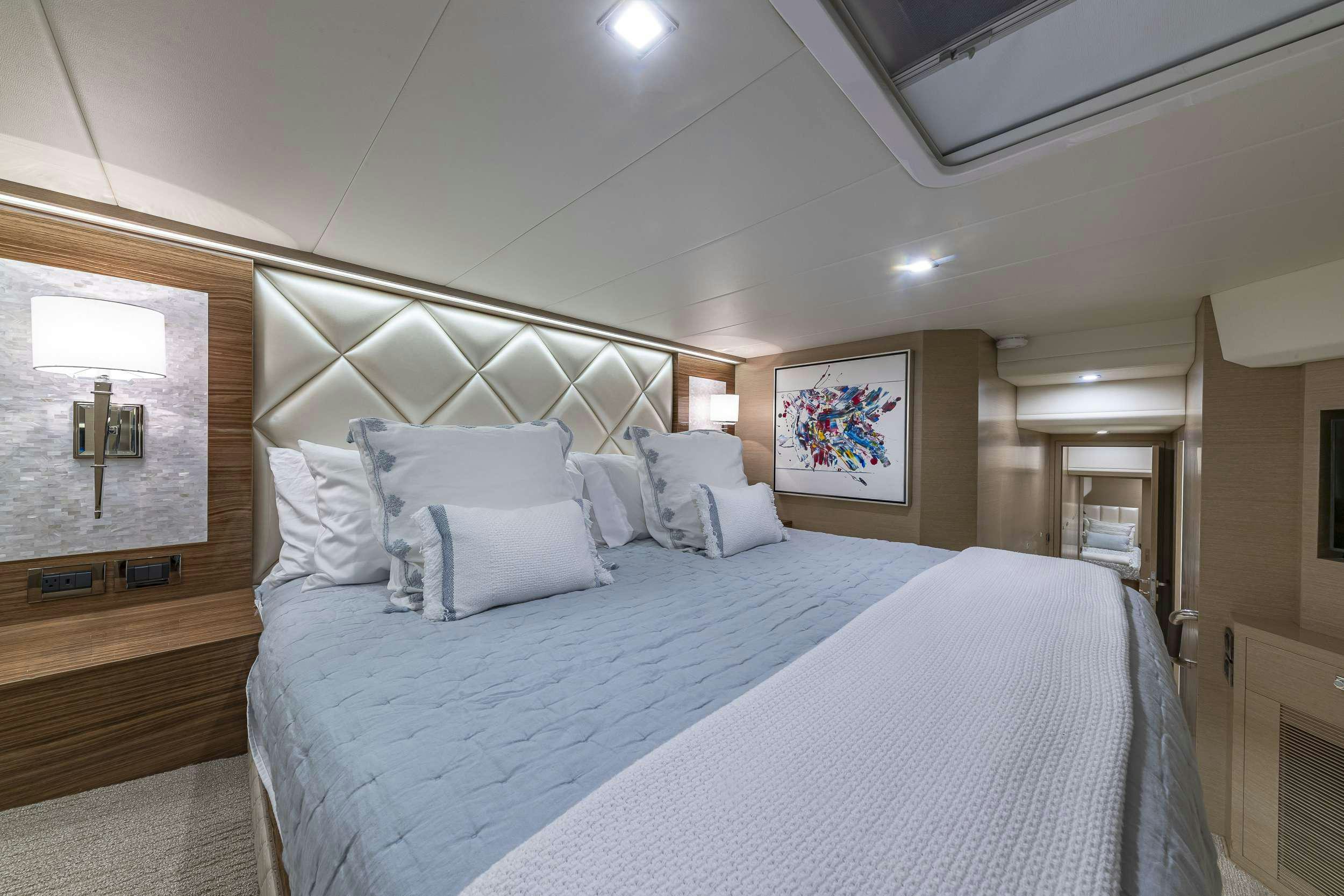 a bed with white sheets aboard OMAKASE Yacht for Charter