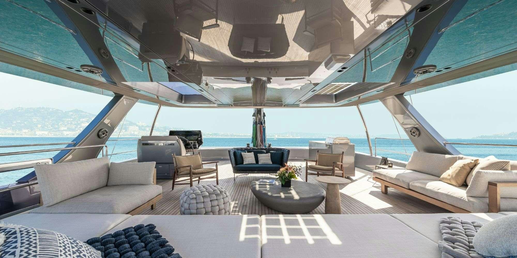 a room with a couch and a table and a large window aboard APOLLO 99 Yacht for Charter