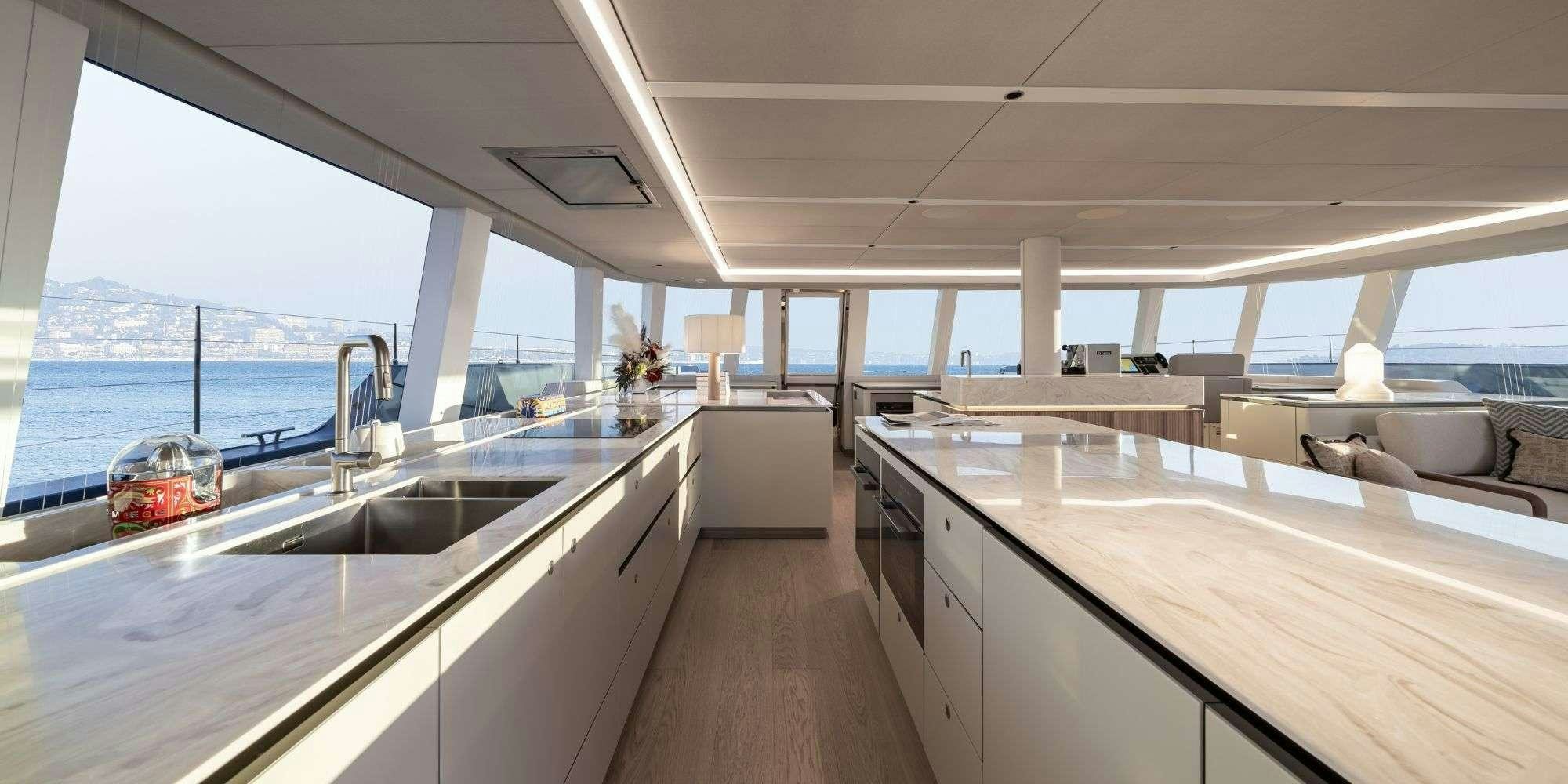 a kitchen with a large window overlooking the ocean aboard APOLLO 99 Yacht for Charter