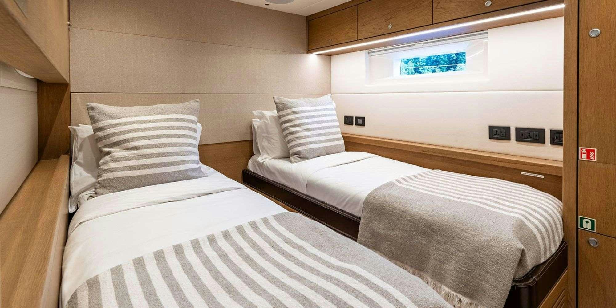 a room with beds and a window aboard CHAMPAGNE HIPPY Yacht for Charter