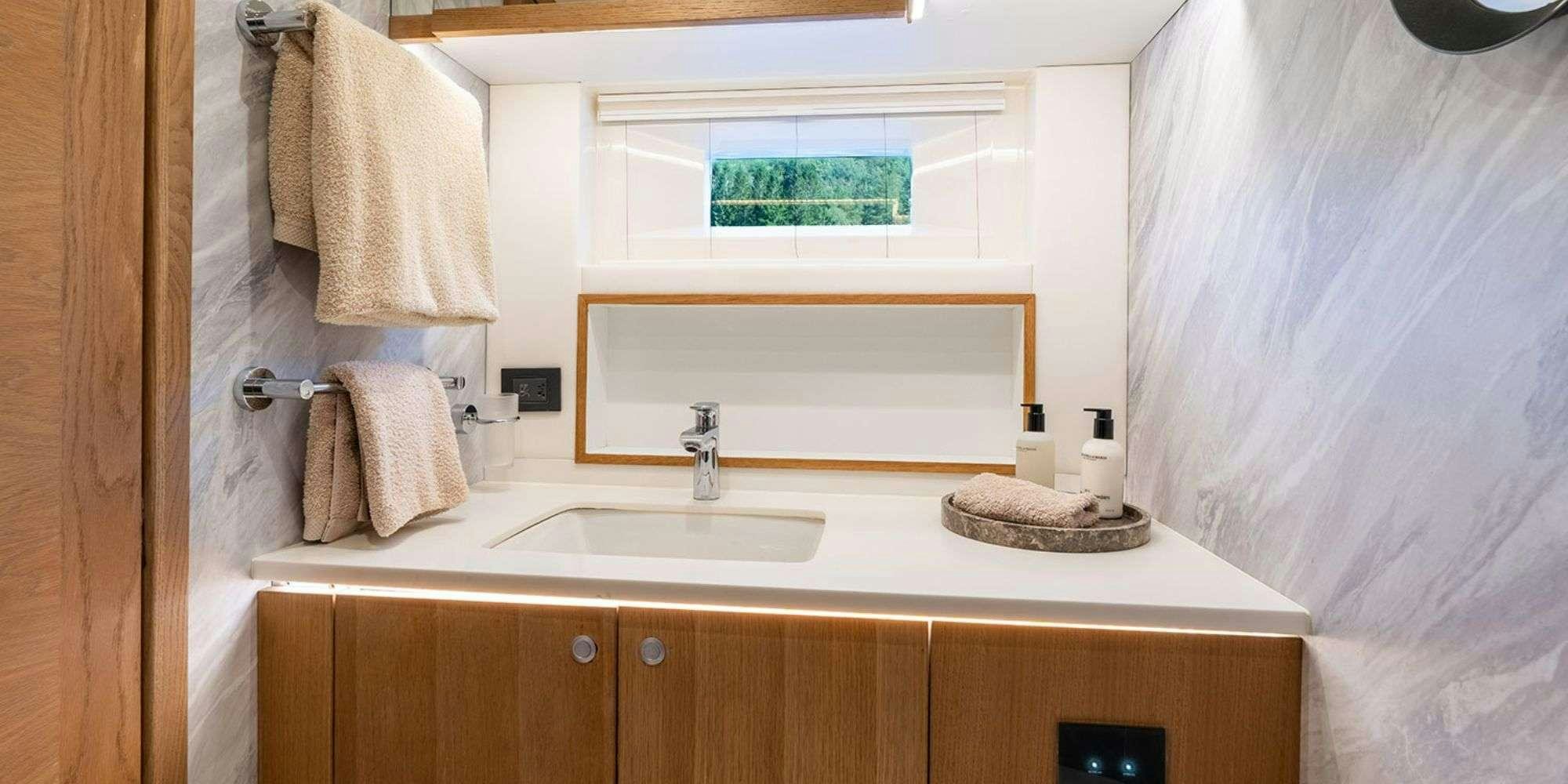 a bathroom with a sink and towels aboard CHAMPAGNE HIPPY Yacht for Charter